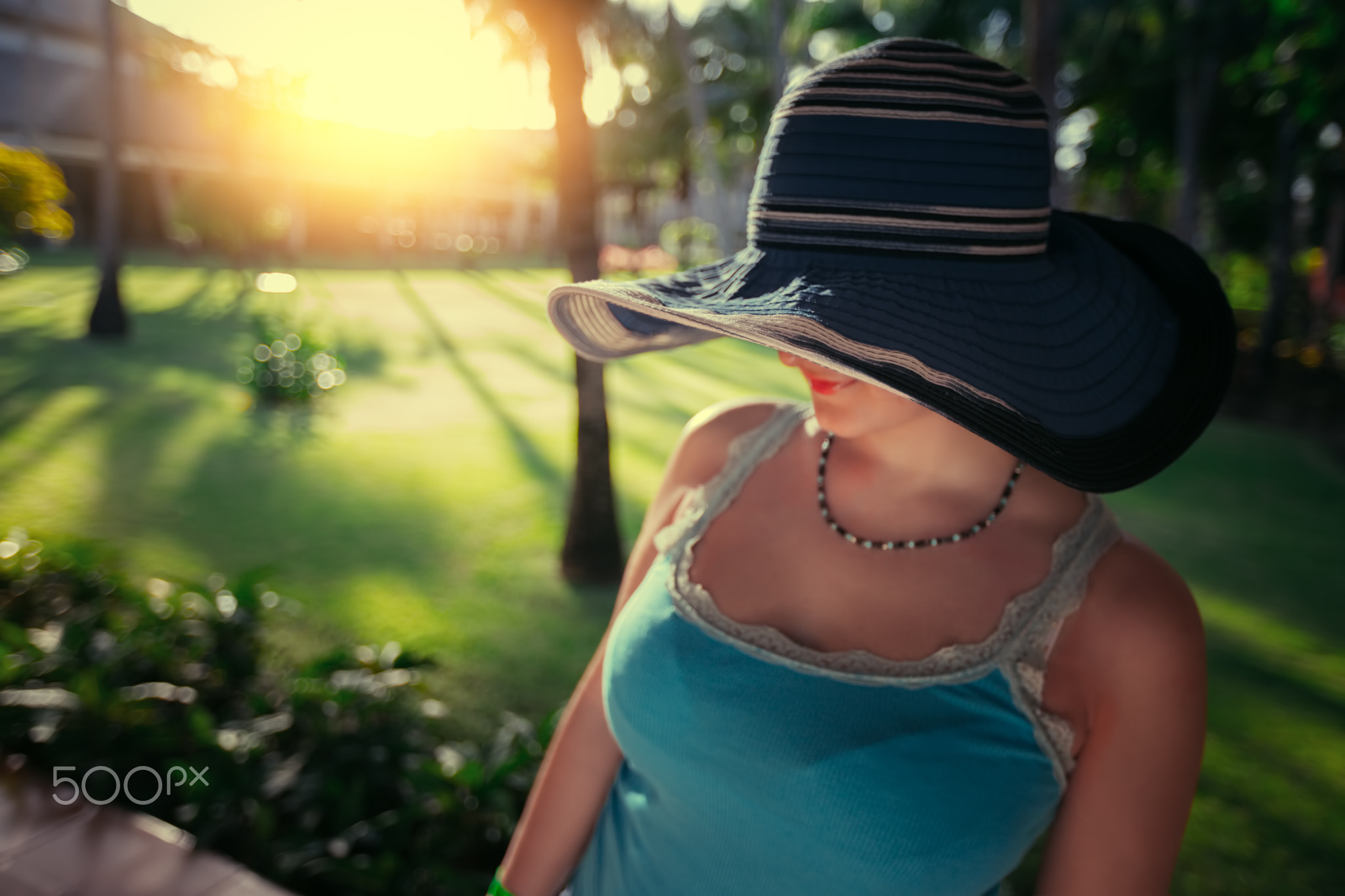 Beautiful young woman with sun hat enjoying her summer holiday i