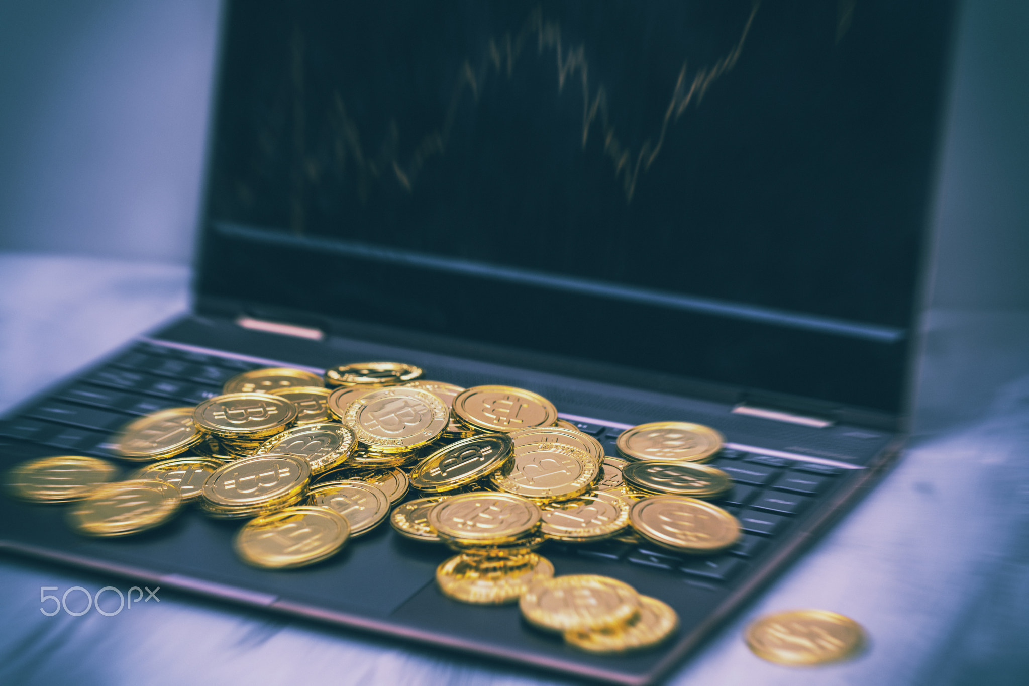 Bitcoin as a viable currency in the information era: shiny bitcoin coins on a laptop