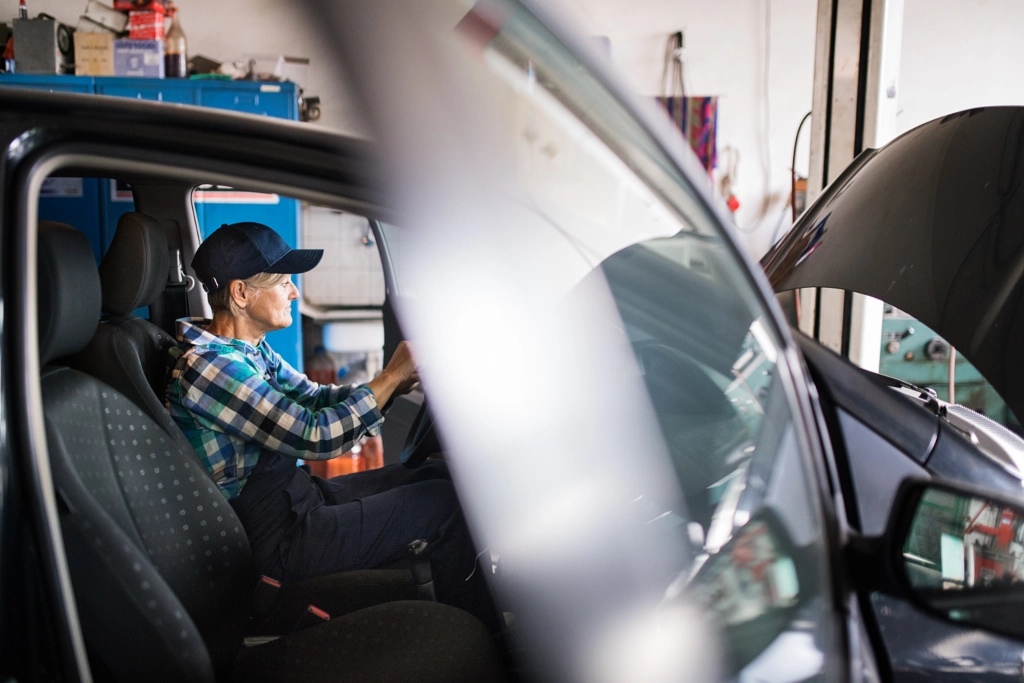 Senior female mechanic repairing a car in a garage. by Jozef Polc on 500px.com