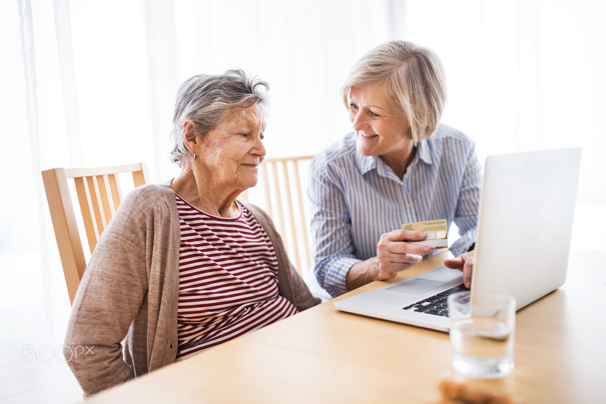 Senior woman with her mother with laptop at home.