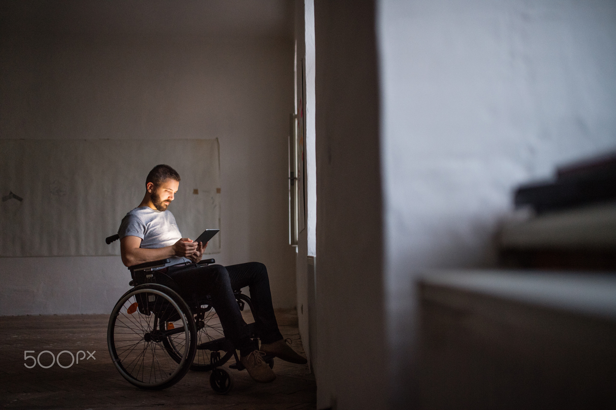 Man in wheelchair working with tablet.