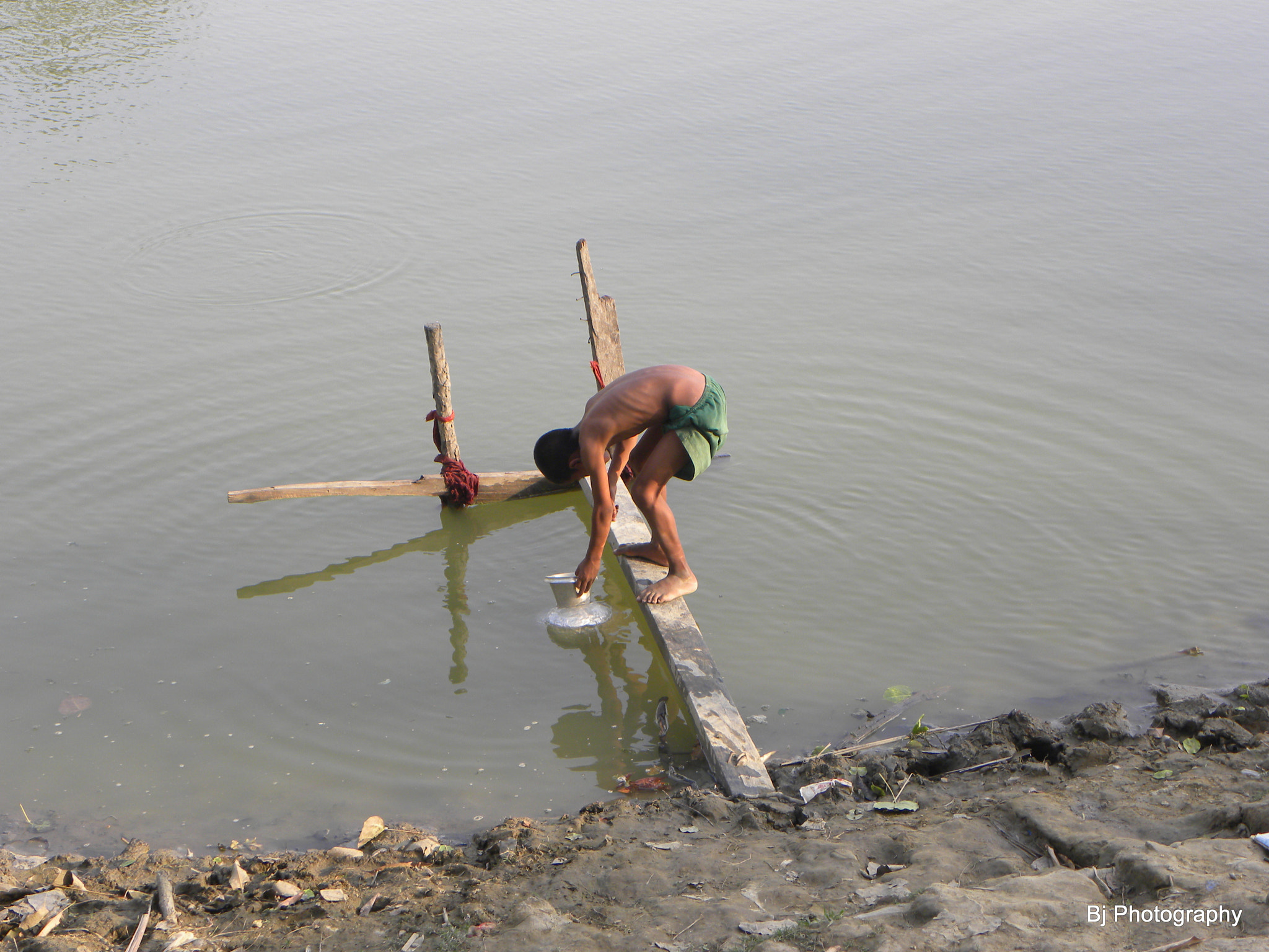 Nikon Coolpix P90 sample photo. Collecting water at village pond photography