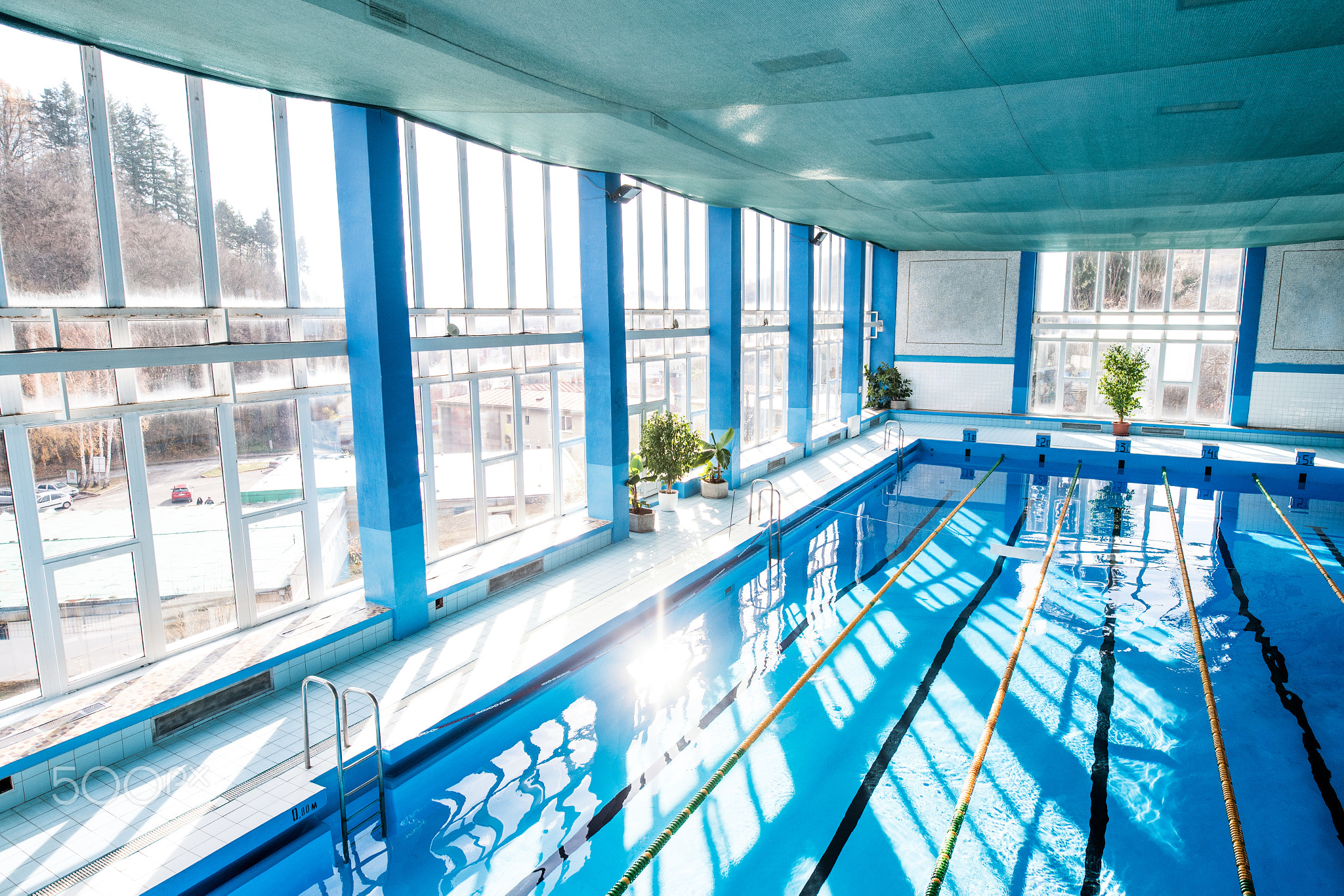 An interior of an indoor public swimming pool.