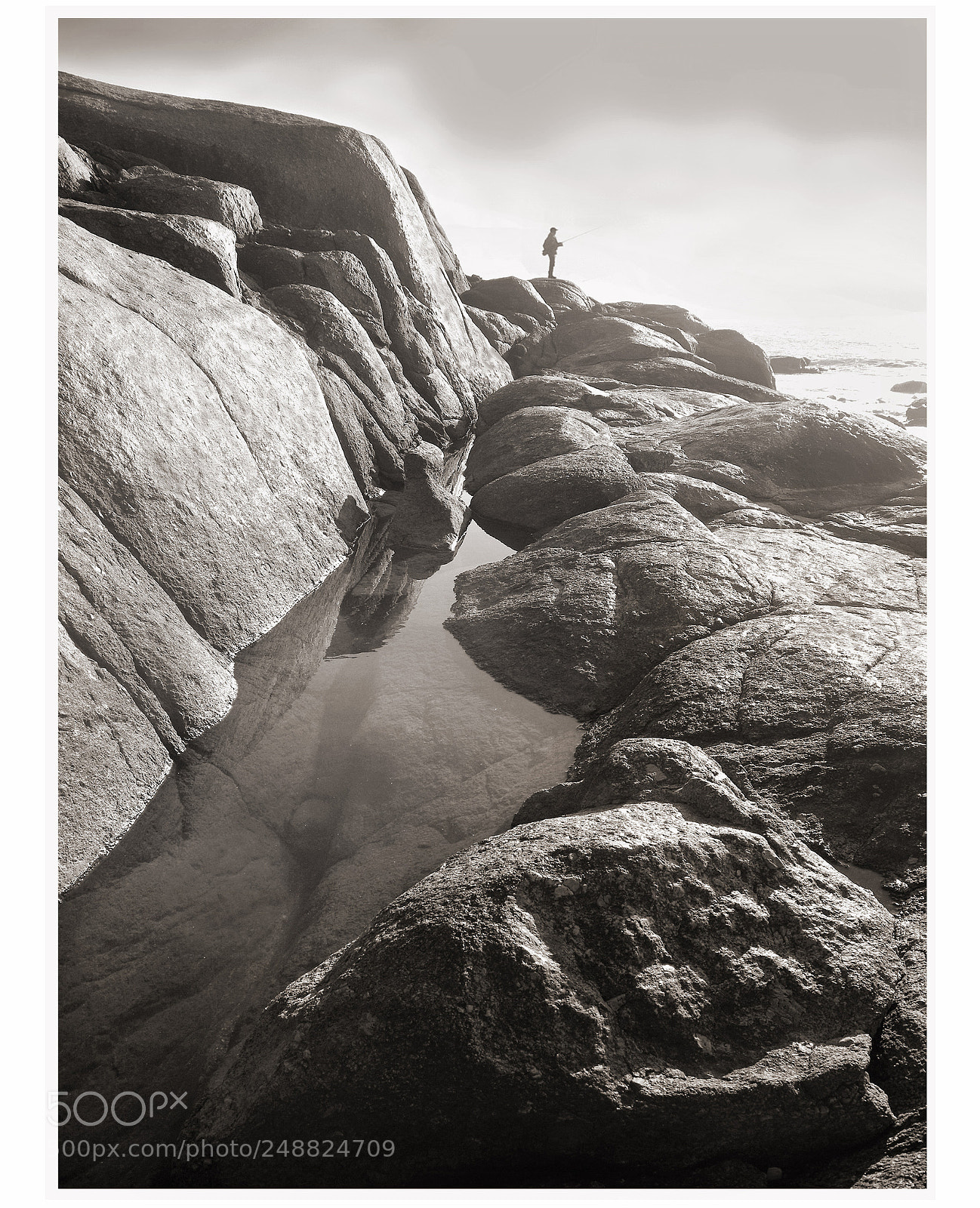 Pentax K20D sample photo. Tiny fisherman on rocks photography