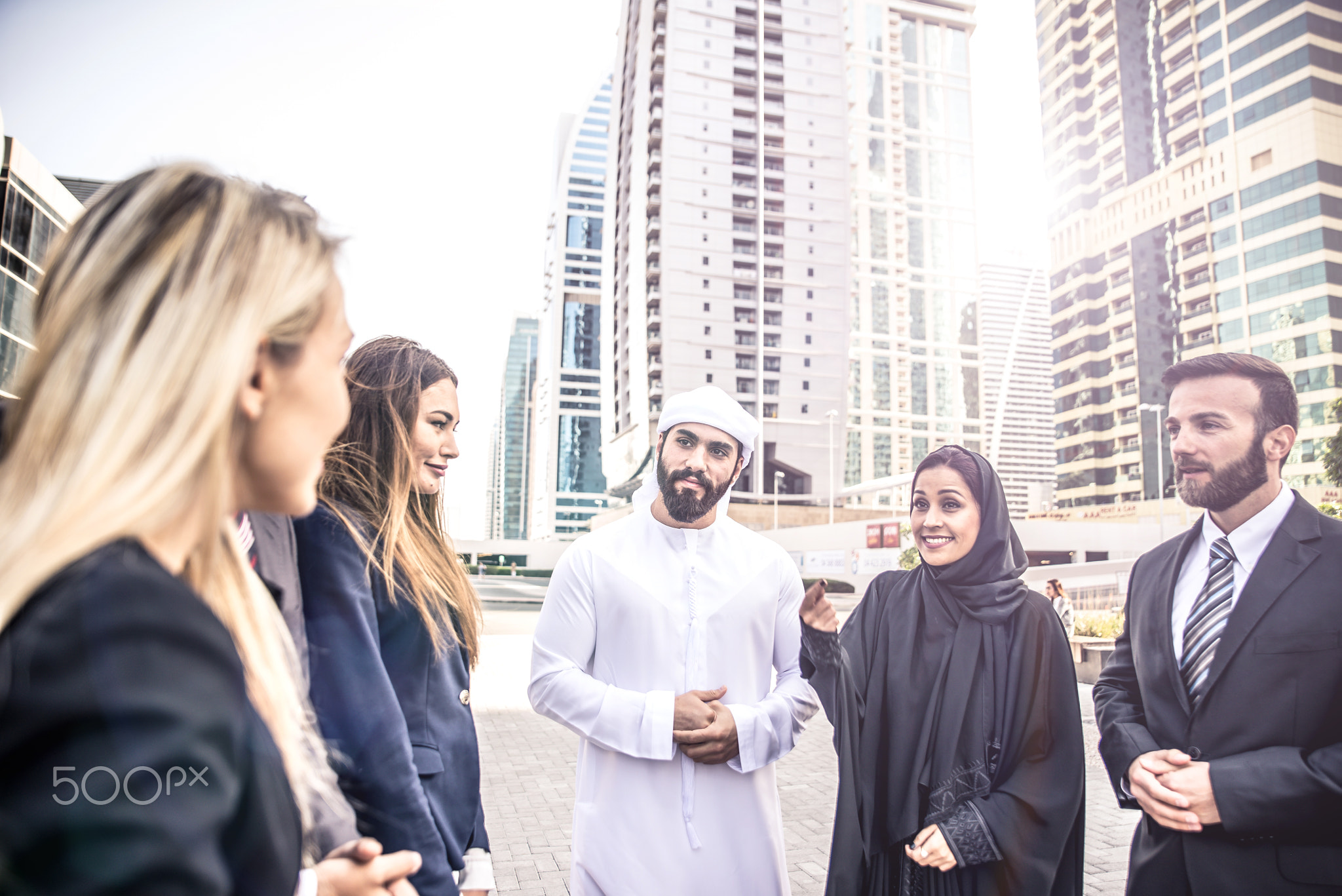 Arabic and western business people speaking about investments