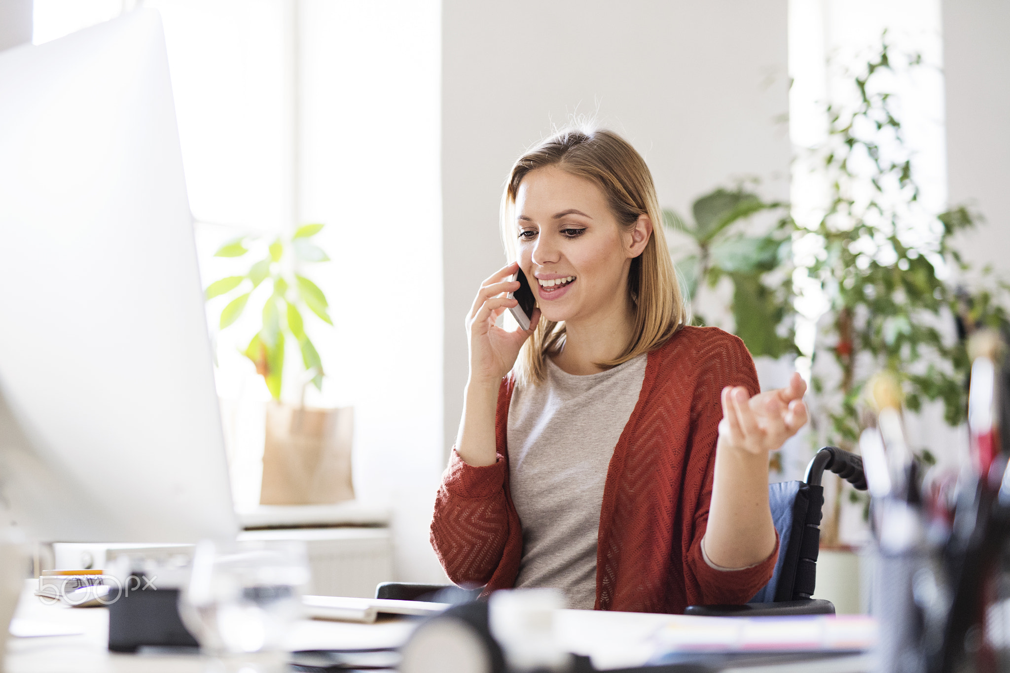 Businesswoman in wheelchair at the desk in her office.