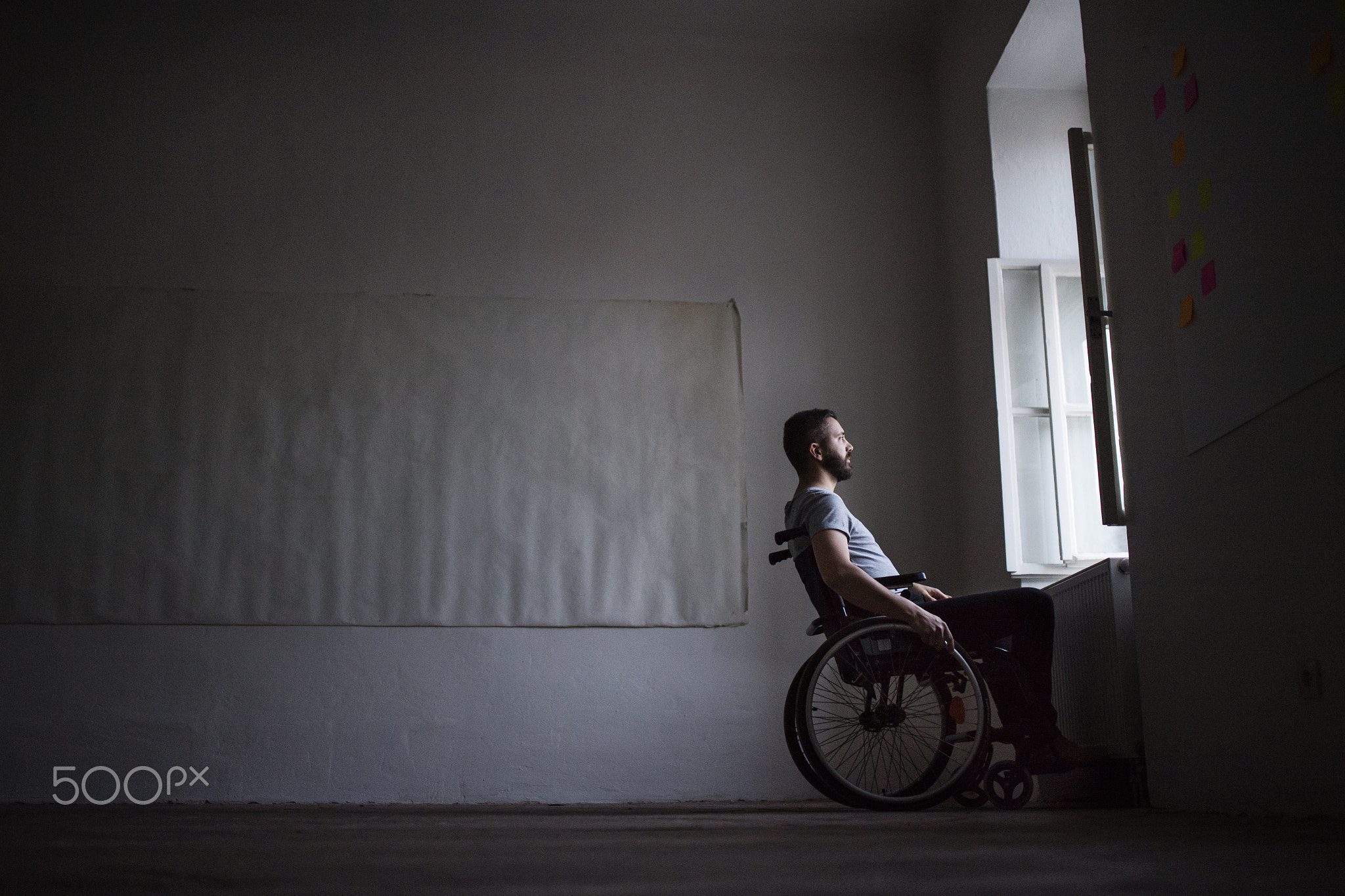 Man in wheelchair looking out of the window.