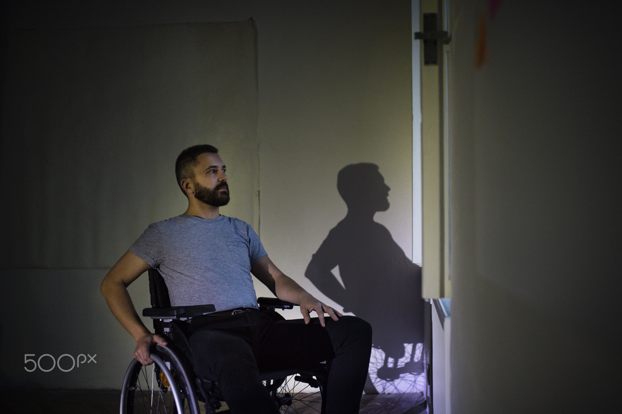 Man in wheelchair looking out of the window.