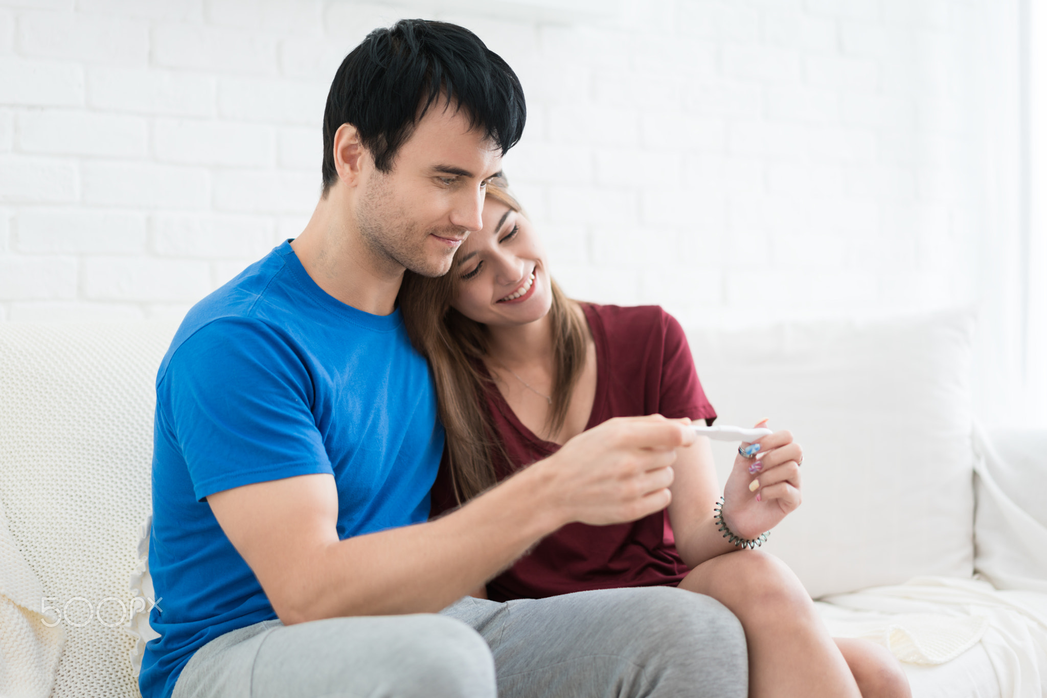 Closeup of happy young woman embracing man after positive pregna