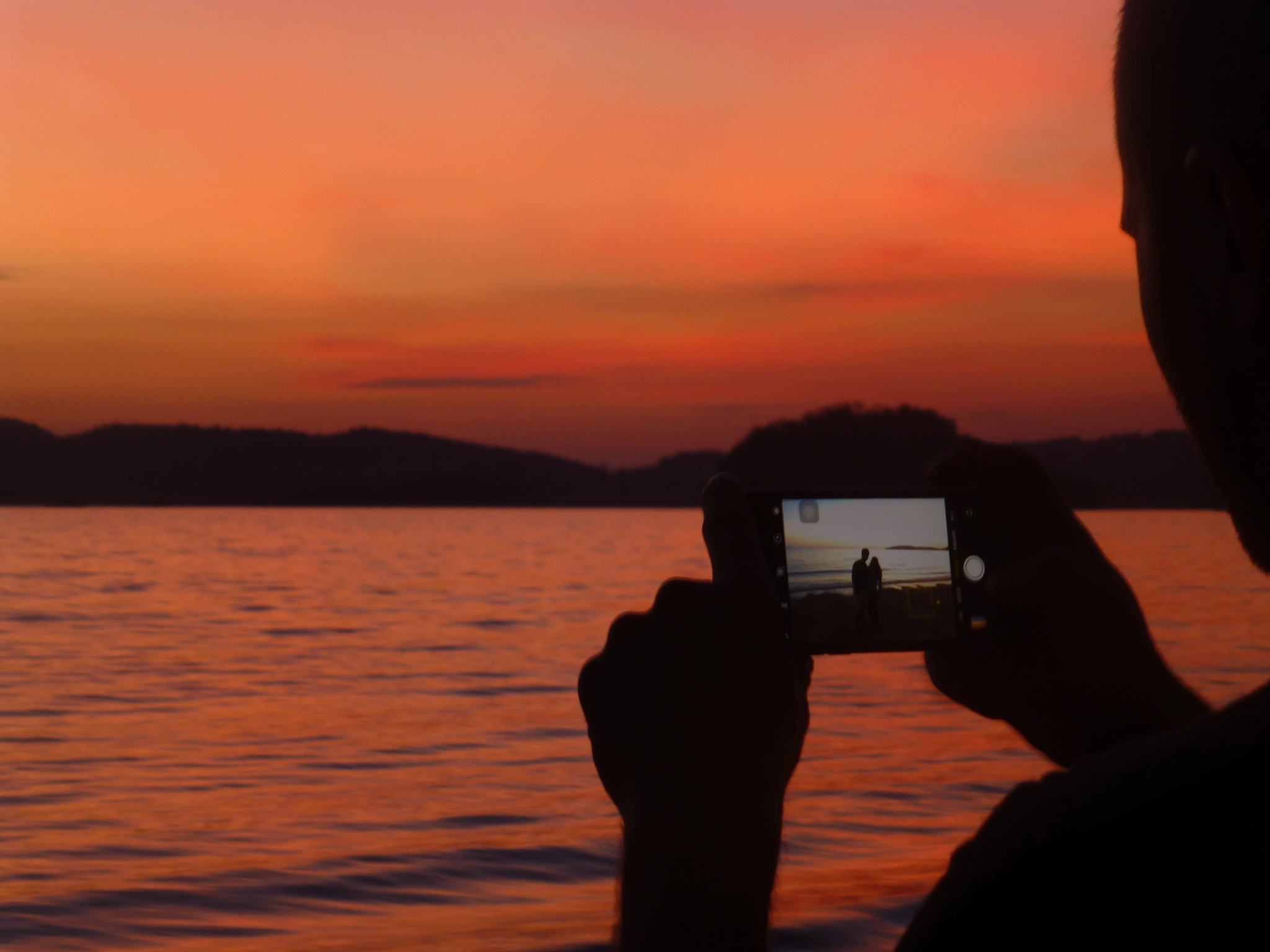 Panasonic Lumix DMC-ZS20 (Lumix DMC-TZ30) sample photo. A man taking a photo on the beach just after sunset on his mobile phone photography