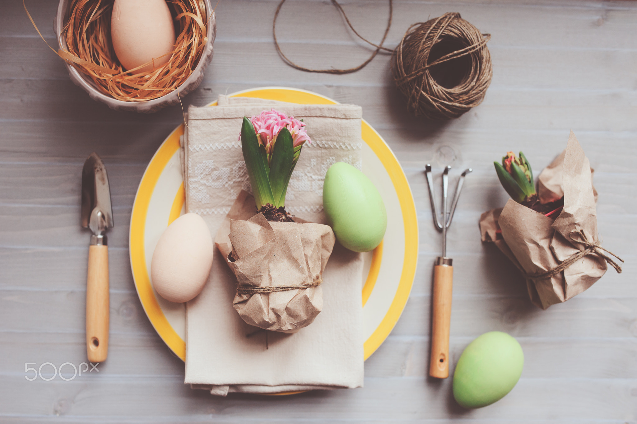 Easter and spring preparations. Hyacinth, eggs and garden tools on table, top view. Selective...