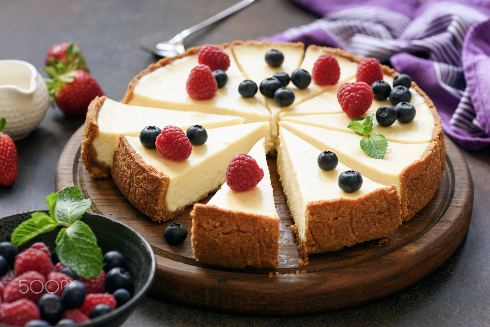 Classic plain New York Cheesecake sliced on wooden board