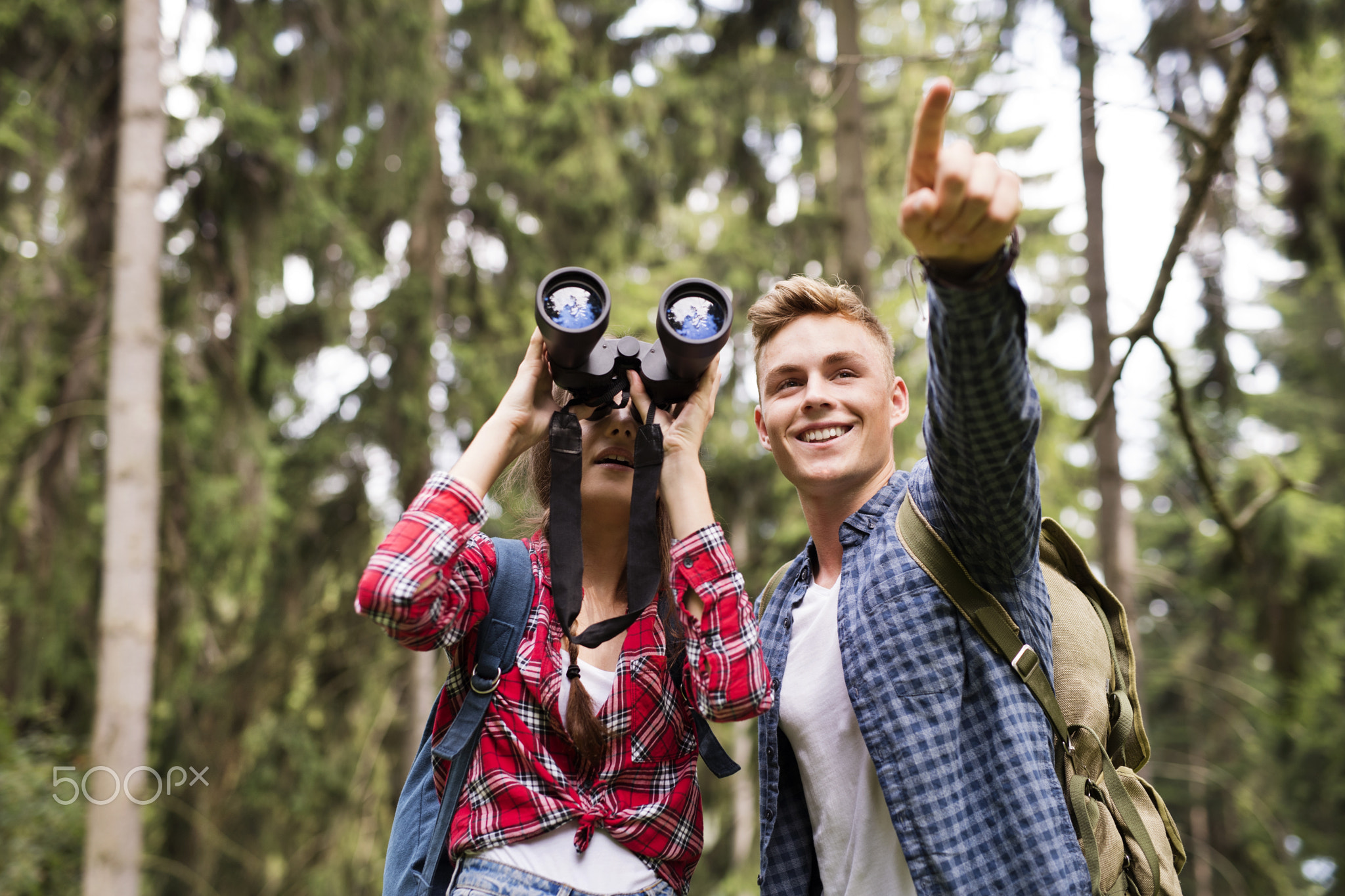 Teenage couple hiking in forest. Summer vacation.