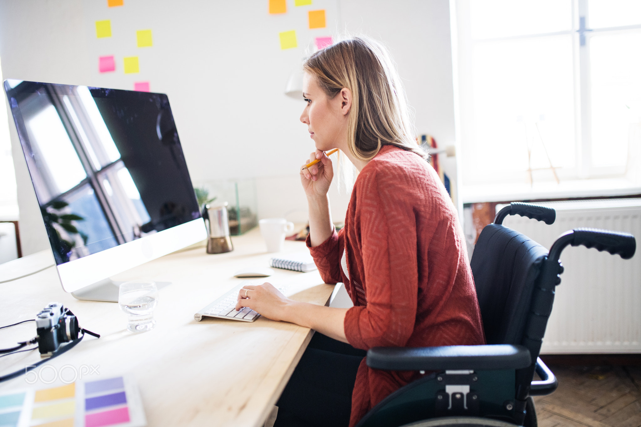 Businesswoman in wheelchair at the desk in her office.