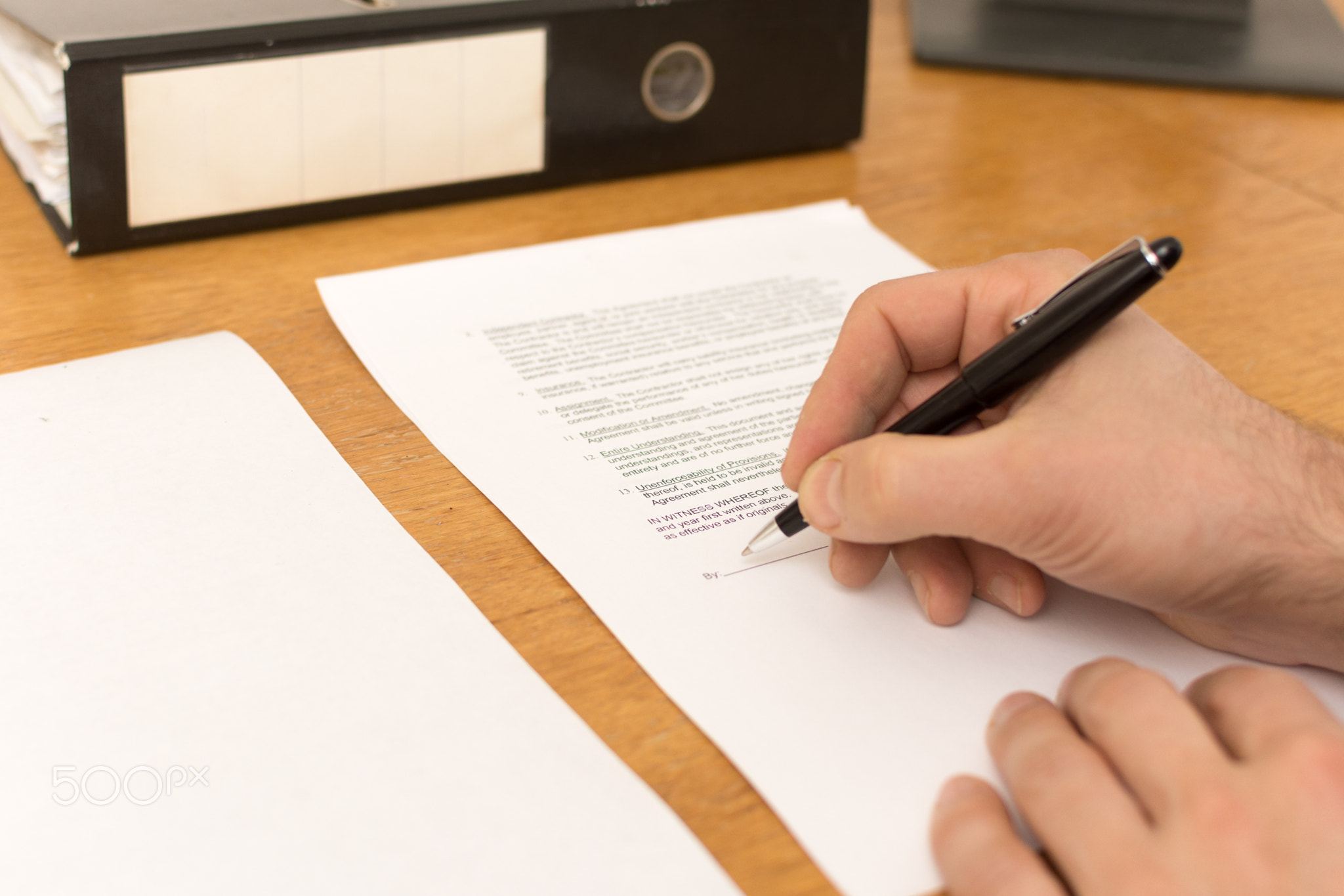 men signing contract at office desk