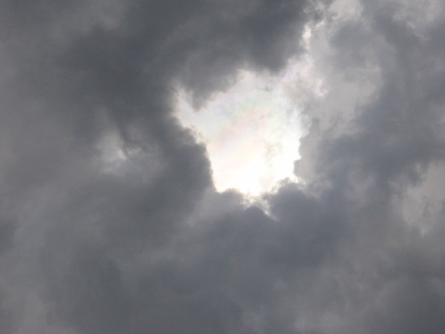 Canon PowerShot A2200 sample photo. There's a bright light and a rainbow behind the face if every dark cloud! photography