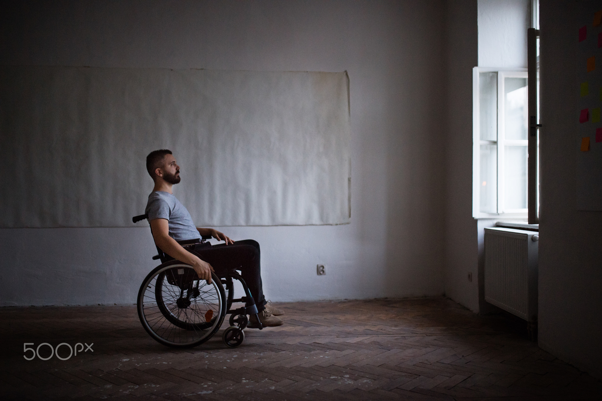 Man in wheelchair looking out of the window.