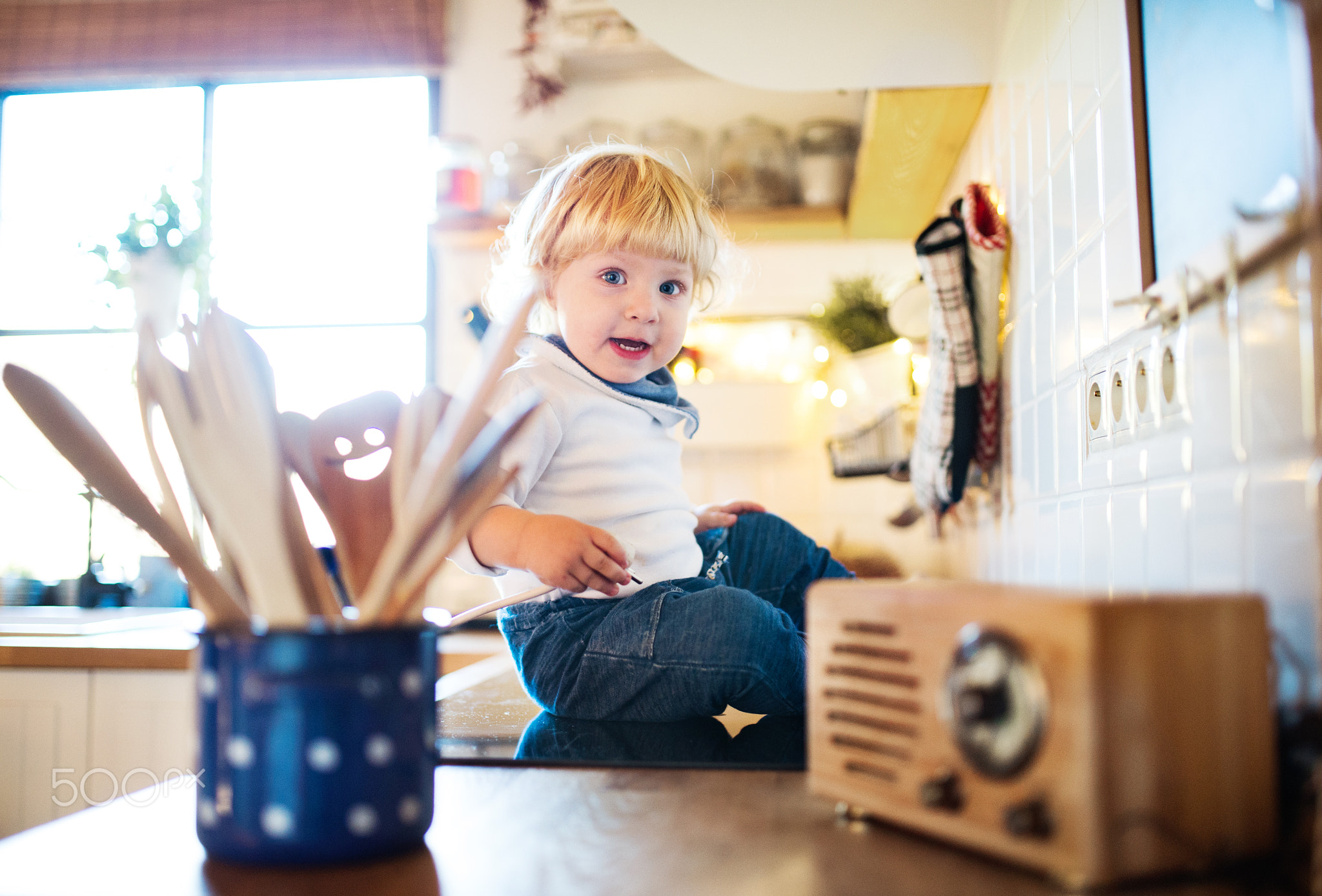 Toddler boy in dangerous situation at home. Child safety concept.