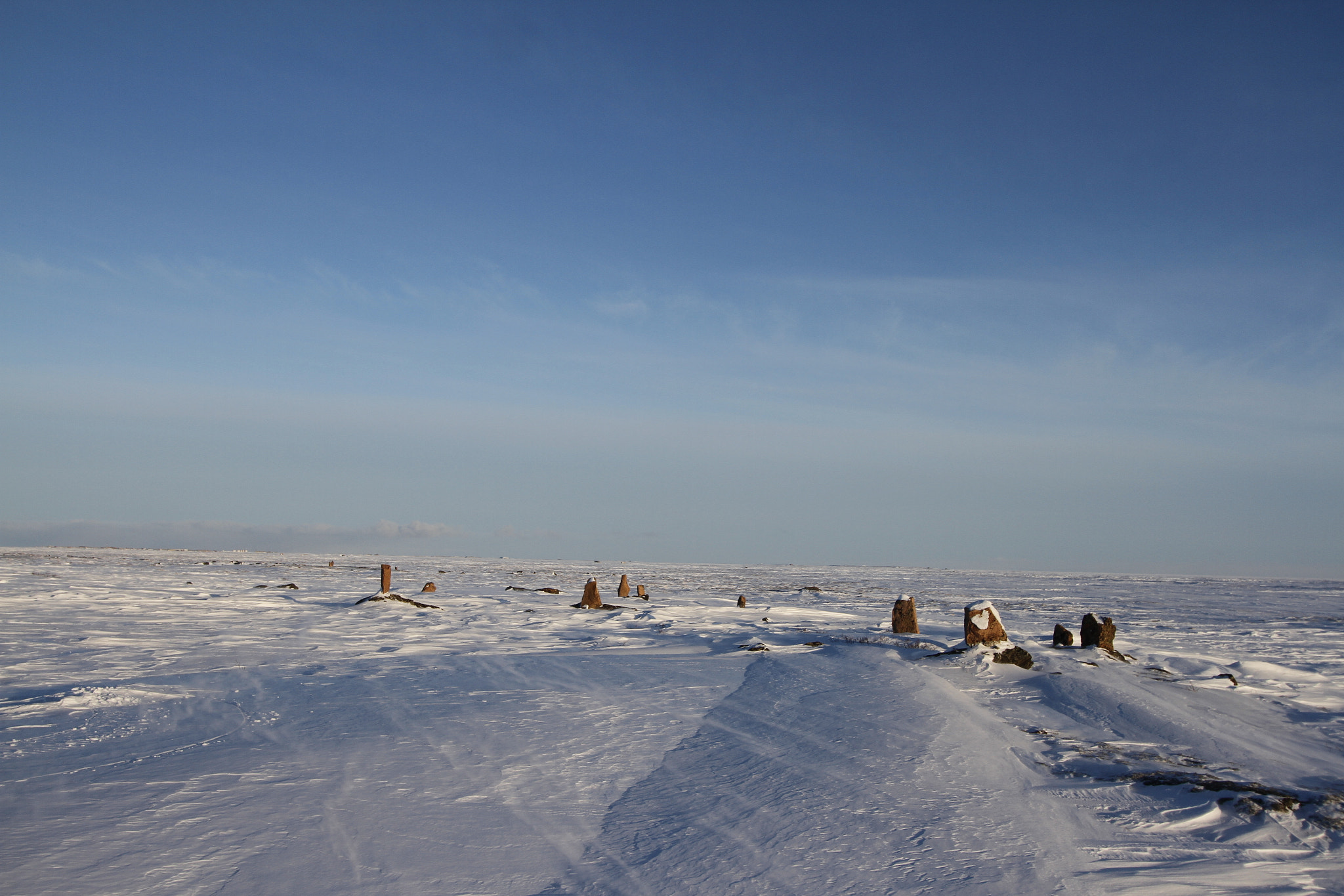 Canon EOS 7D + Canon EF-S 10-22mm F3.5-4.5 USM sample photo. Standing stones found along an arctic landscape with snow on the ground photography