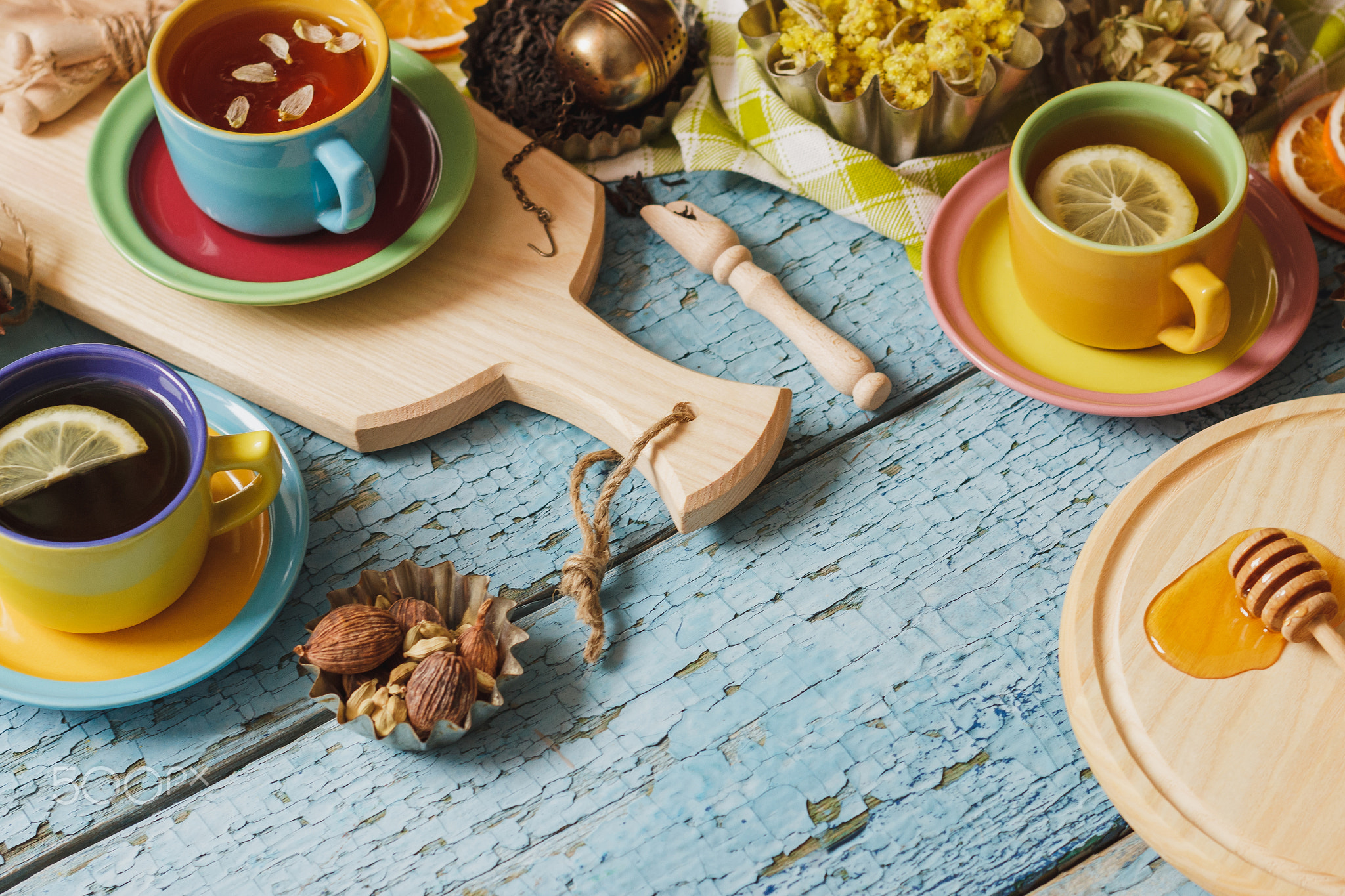 Cups with herbal tea and pieces of lemon, dried herbs and different decorations