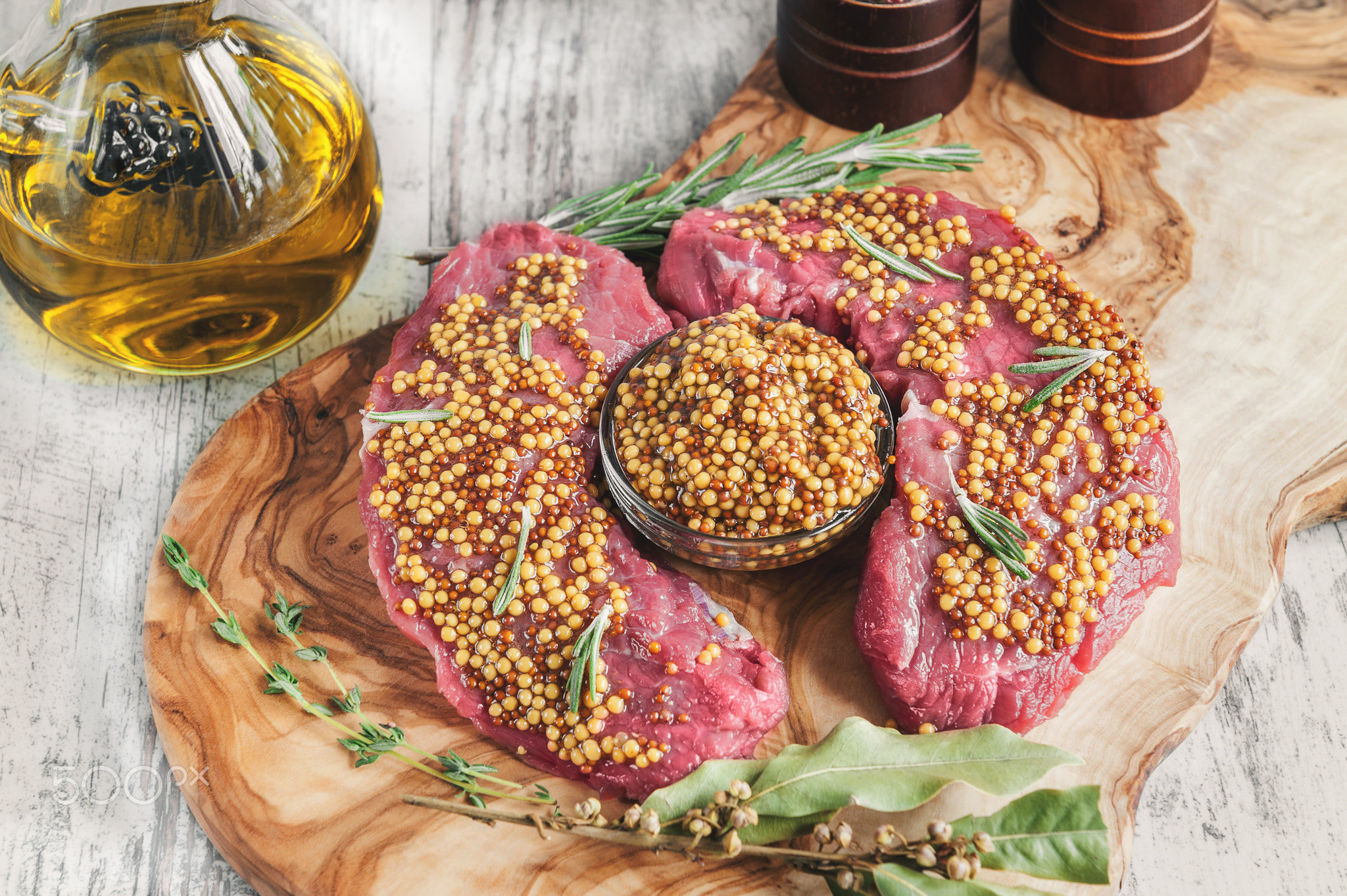 Cuts of beef for grilling on a cutting Board olive wood with pickled Dijon mustard, rosemary and...