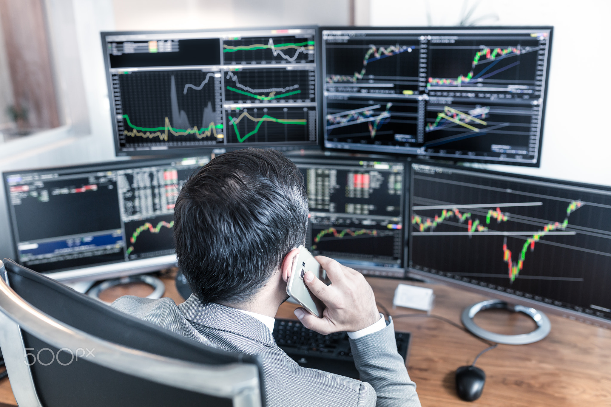 Over the shoulder view of computer screens and stock broker trading online.