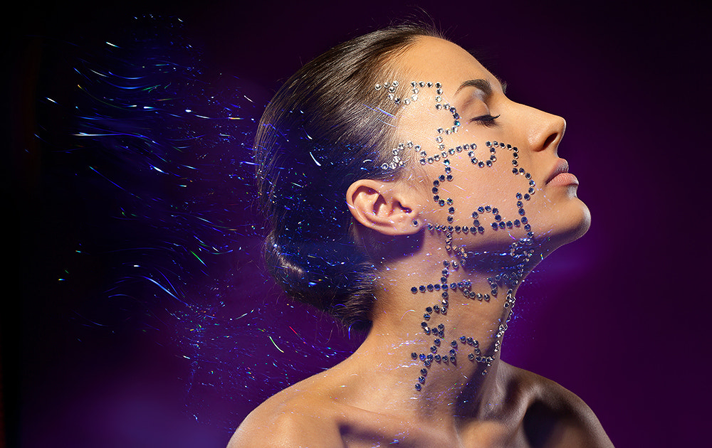 Fashion art portrait of female with beauty crystal puzzle on her face