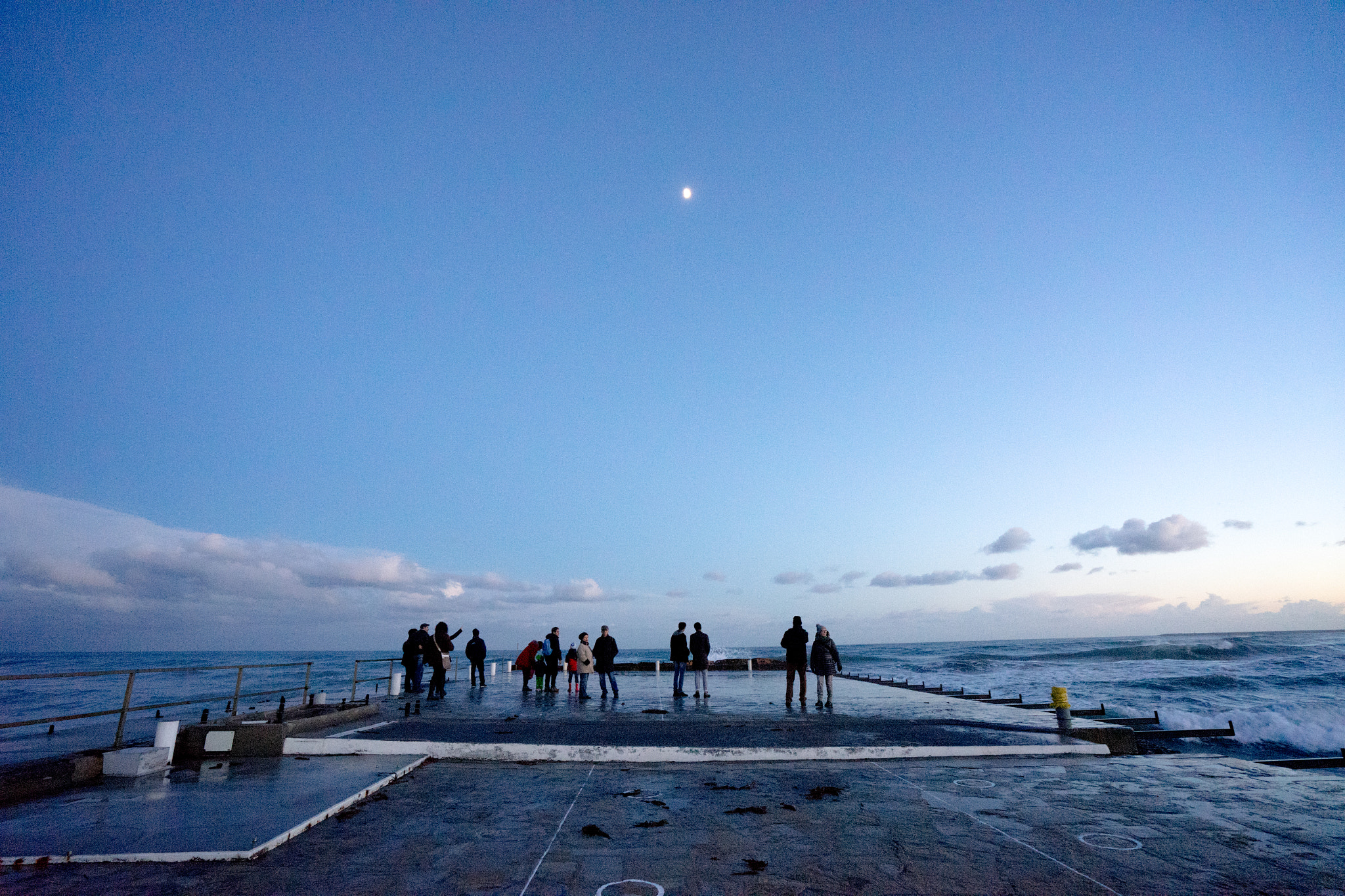 People staring the moon on seascape