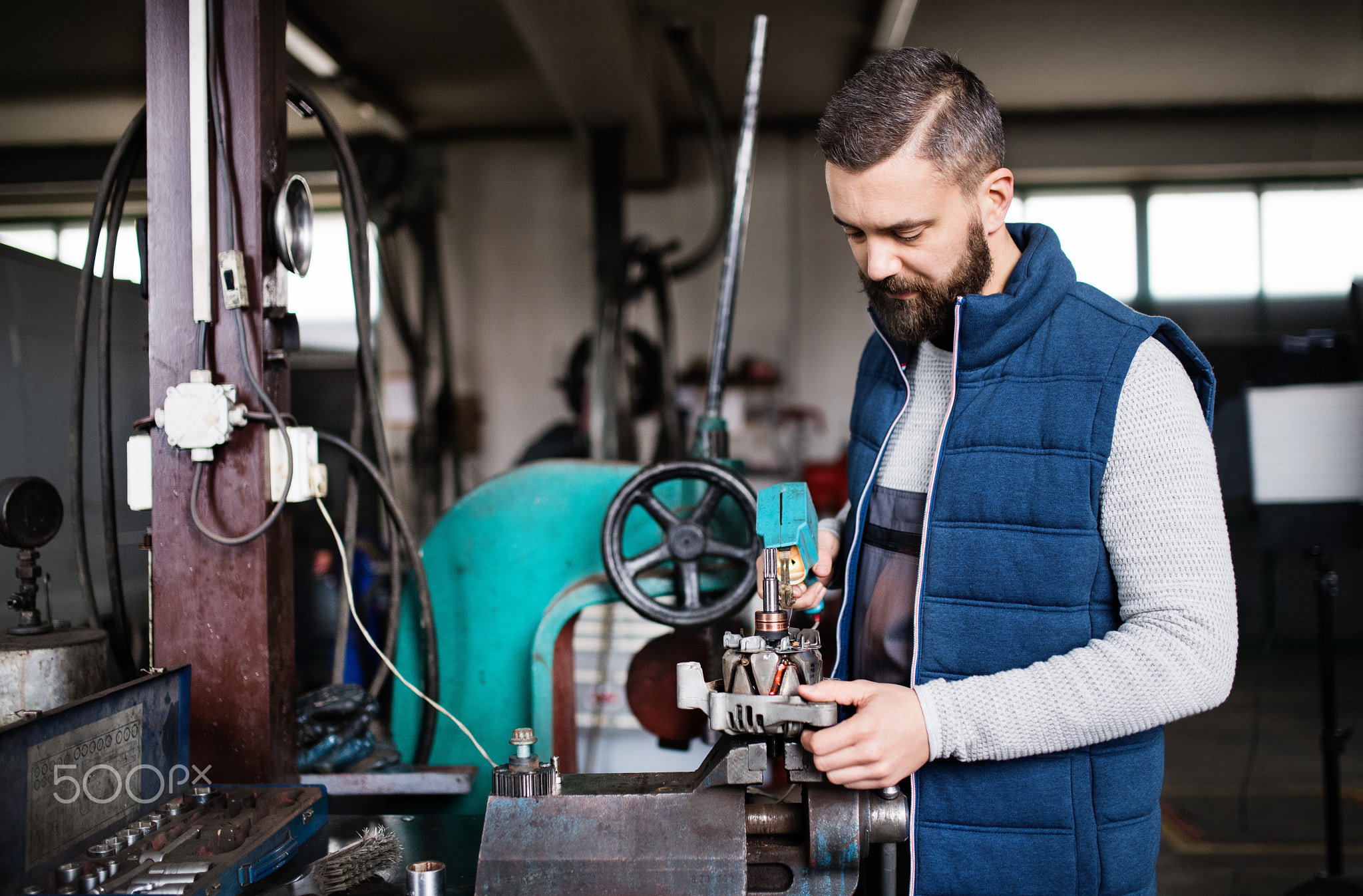 Man mechanic repairing a car in a garage.