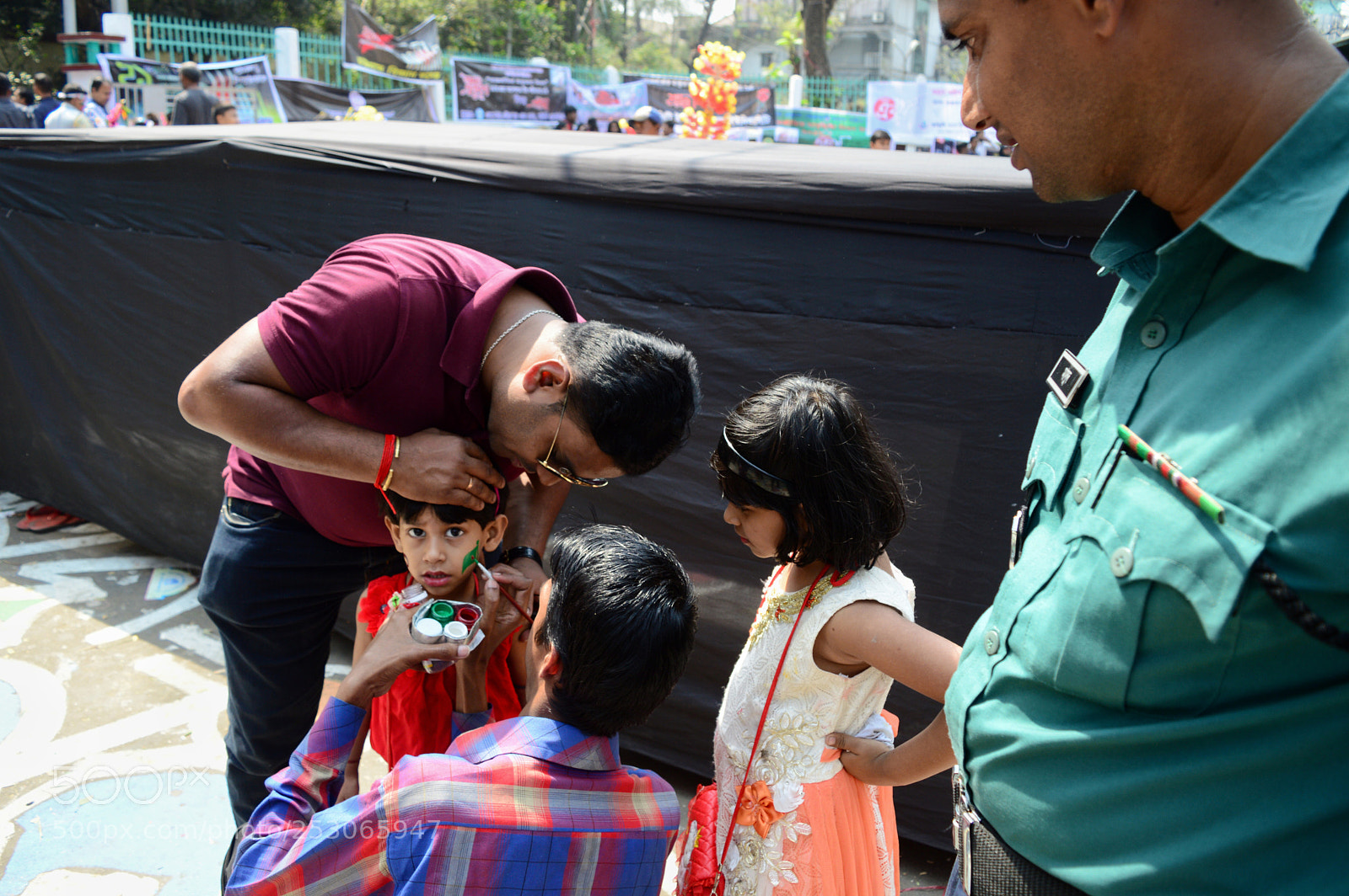Nikon D3200 sample photo. A policeman watching face-painting photography