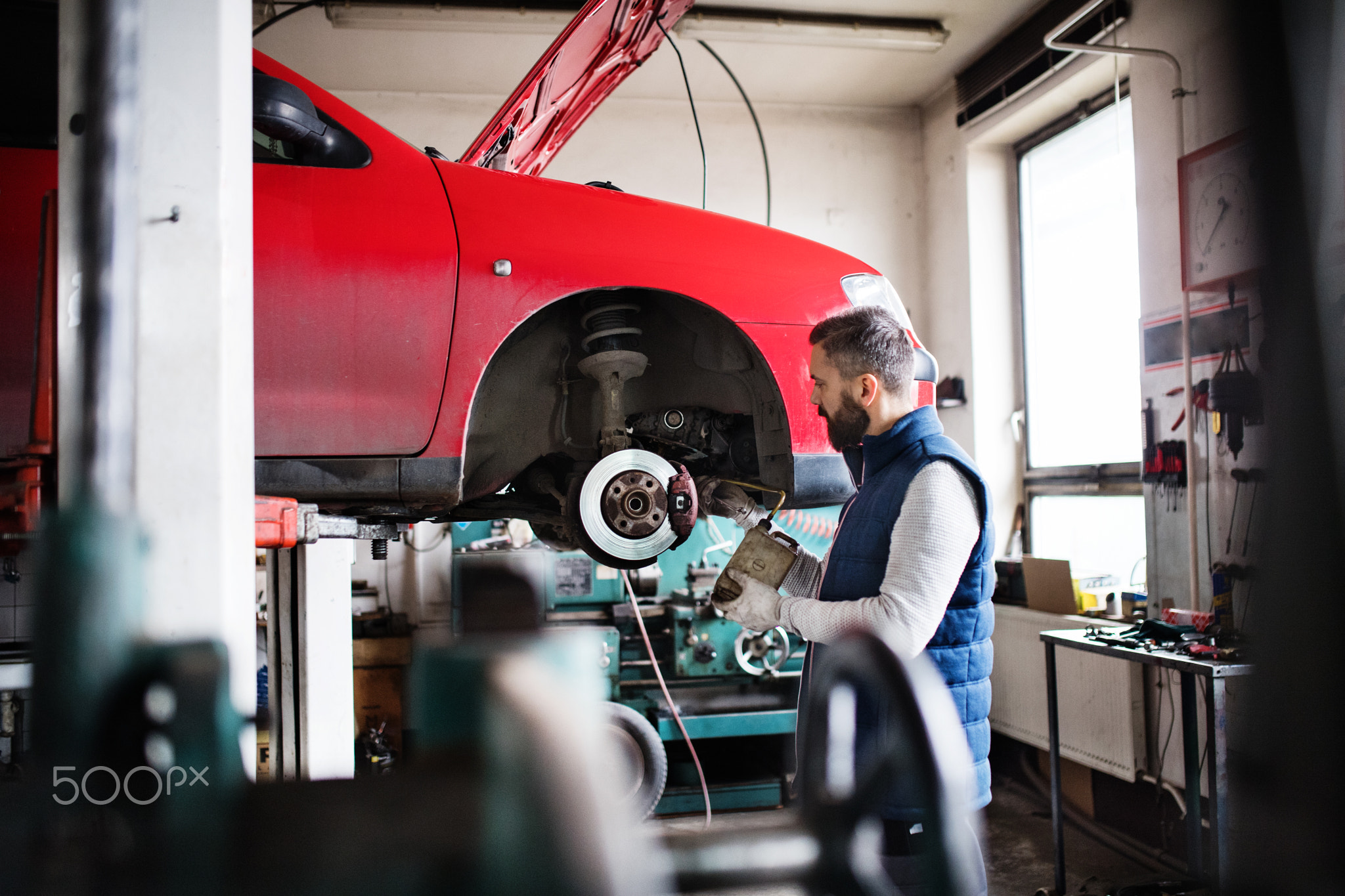 Man mechanic repairing a car in a garage.