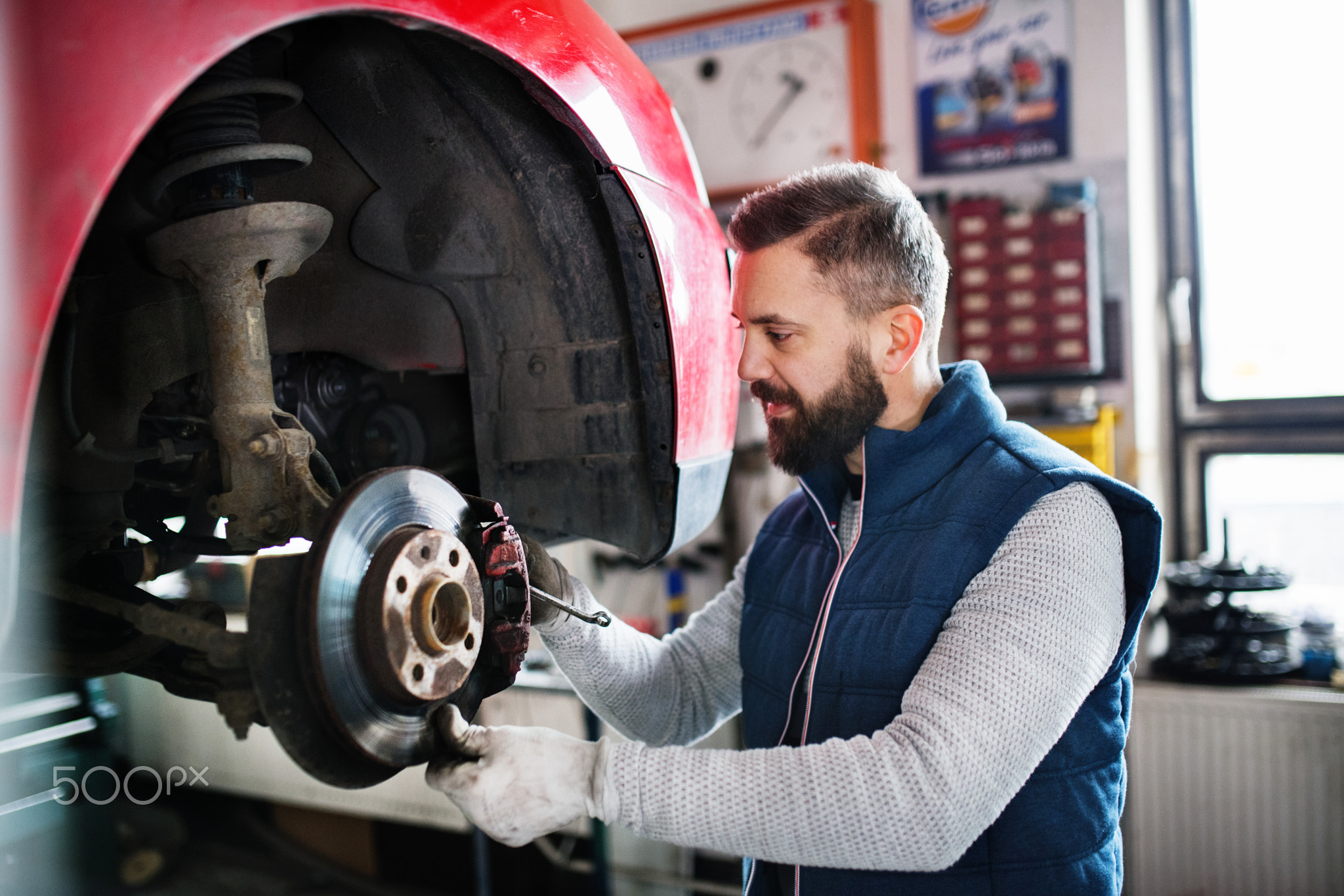 Man mechanic repairing a car in a garage.