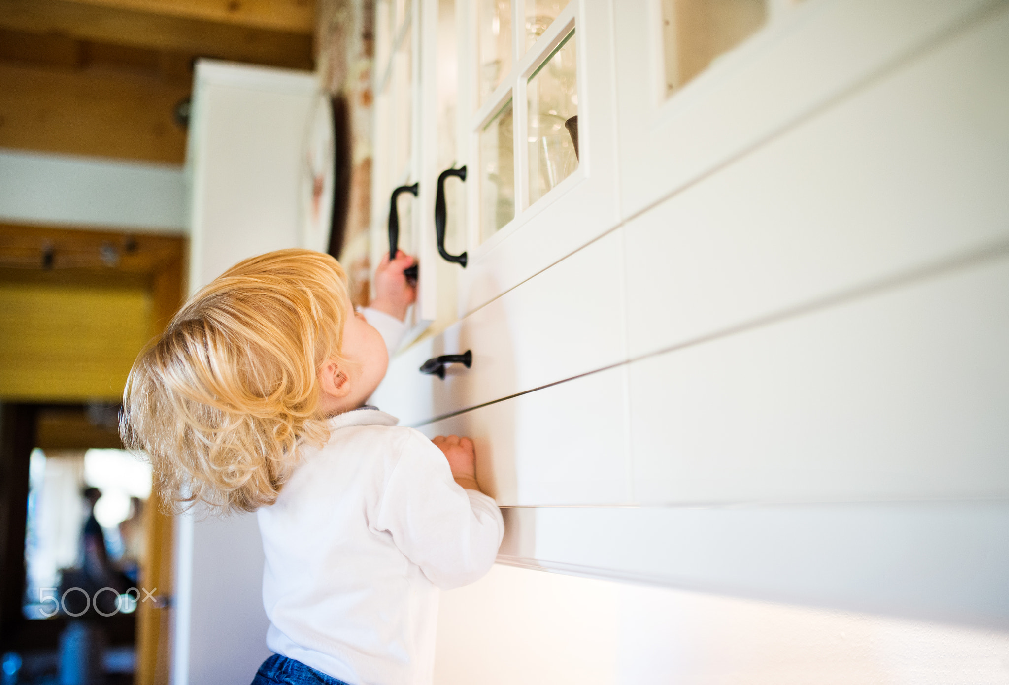 Toddler boy in dangerous situation at home. Child safety concept.