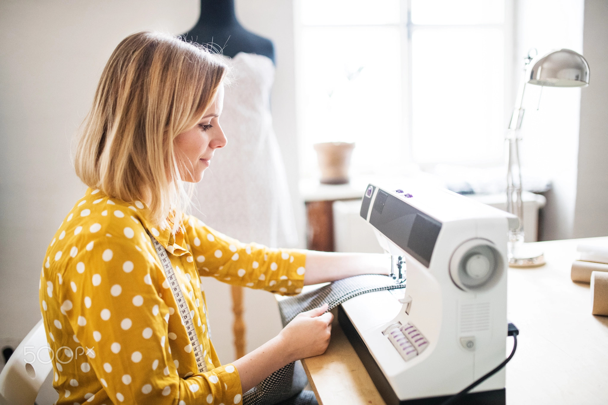 Young woman using sewing machine, startup business.