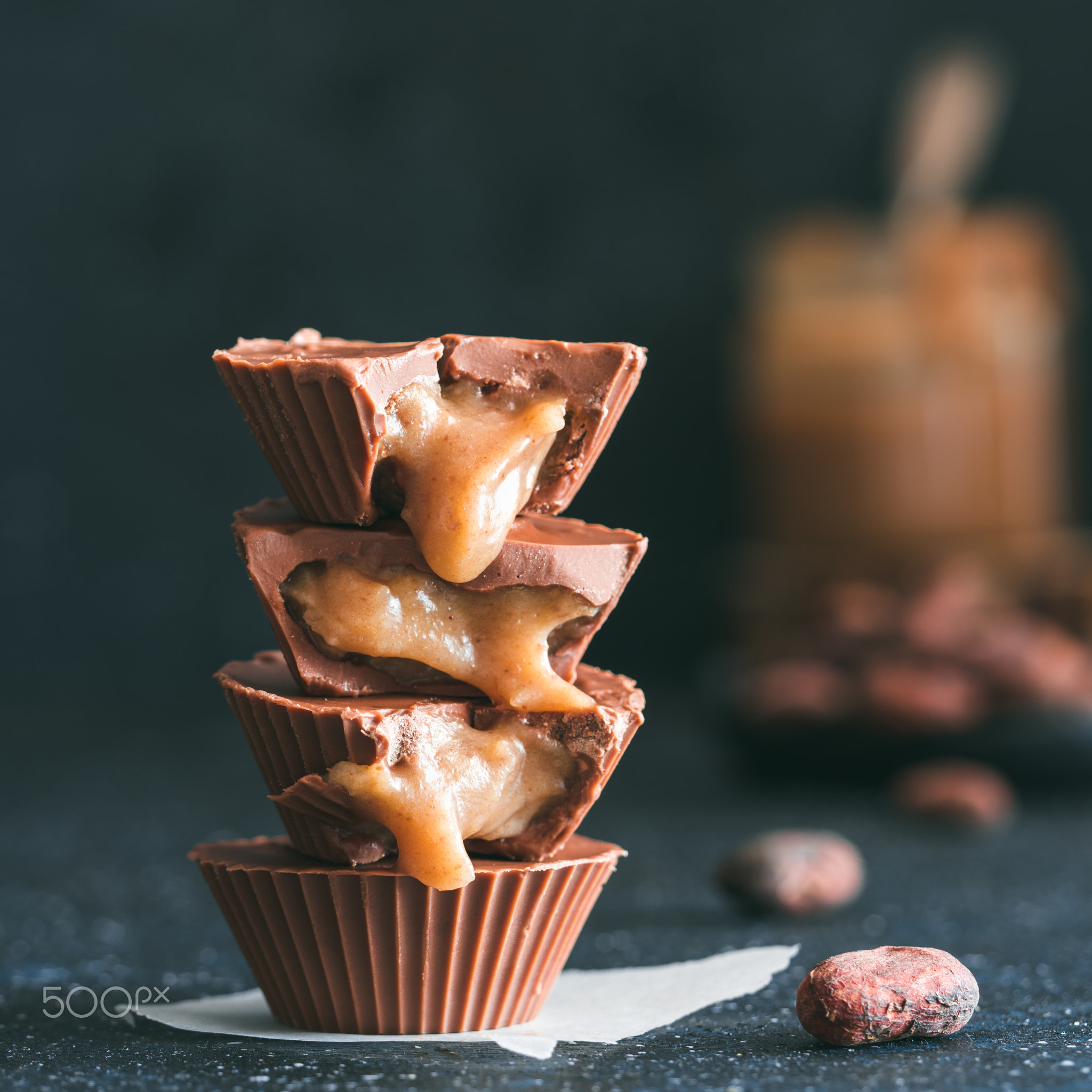 Stack of vegan chocolate cups with caramel on white