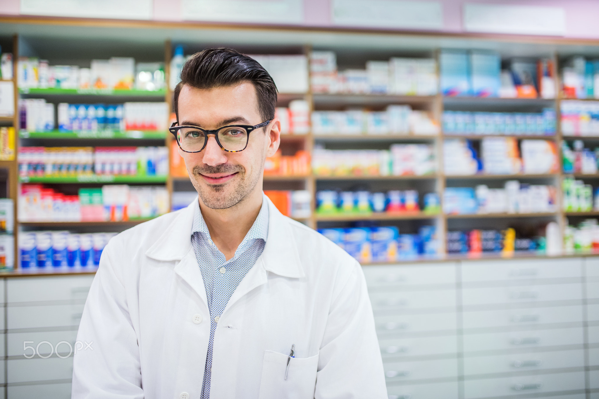 Portrait of a young friendly male pharmacist.