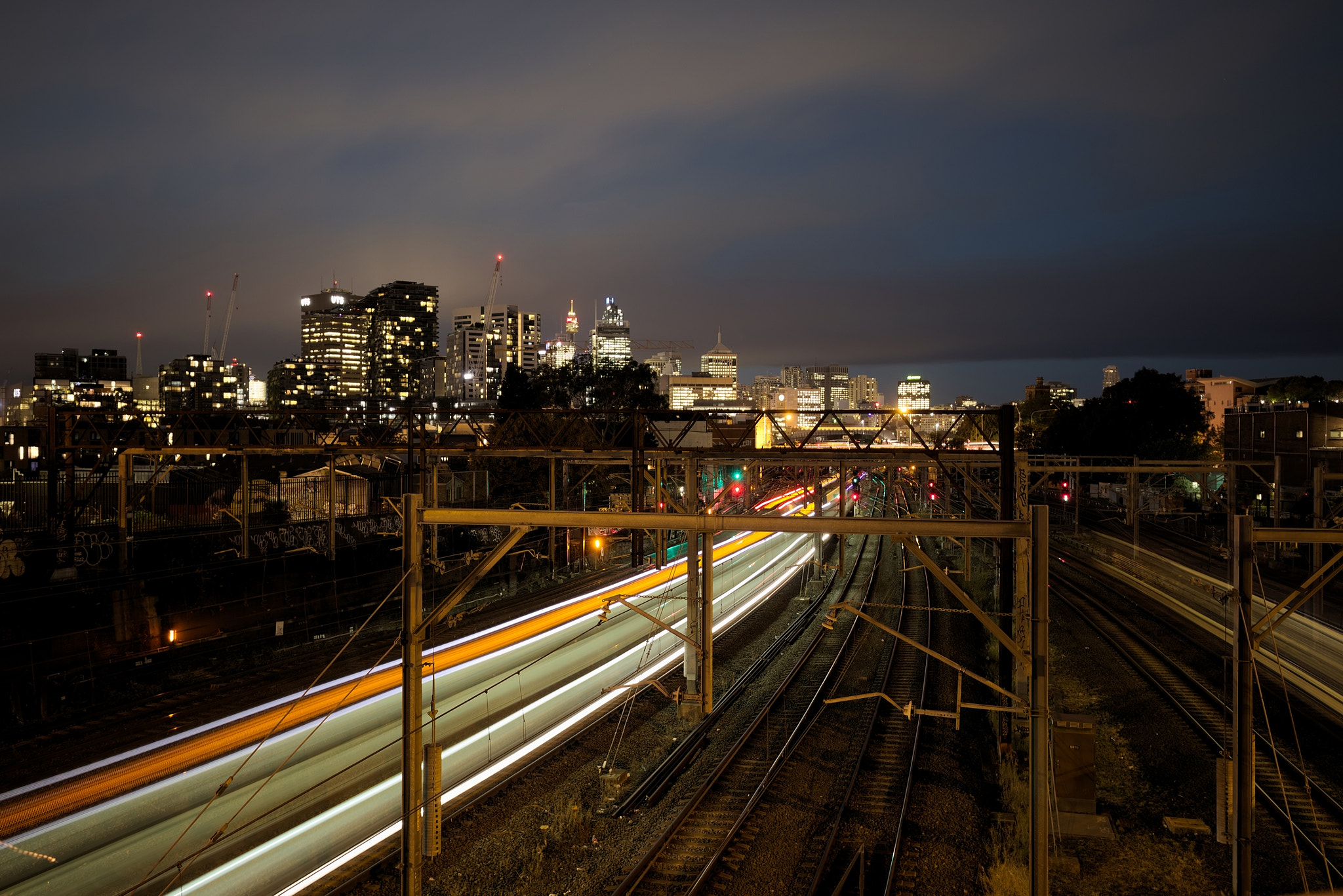 Canon EF 16-35mm F4L IS USM sample photo. Light stretches over train tracks photography