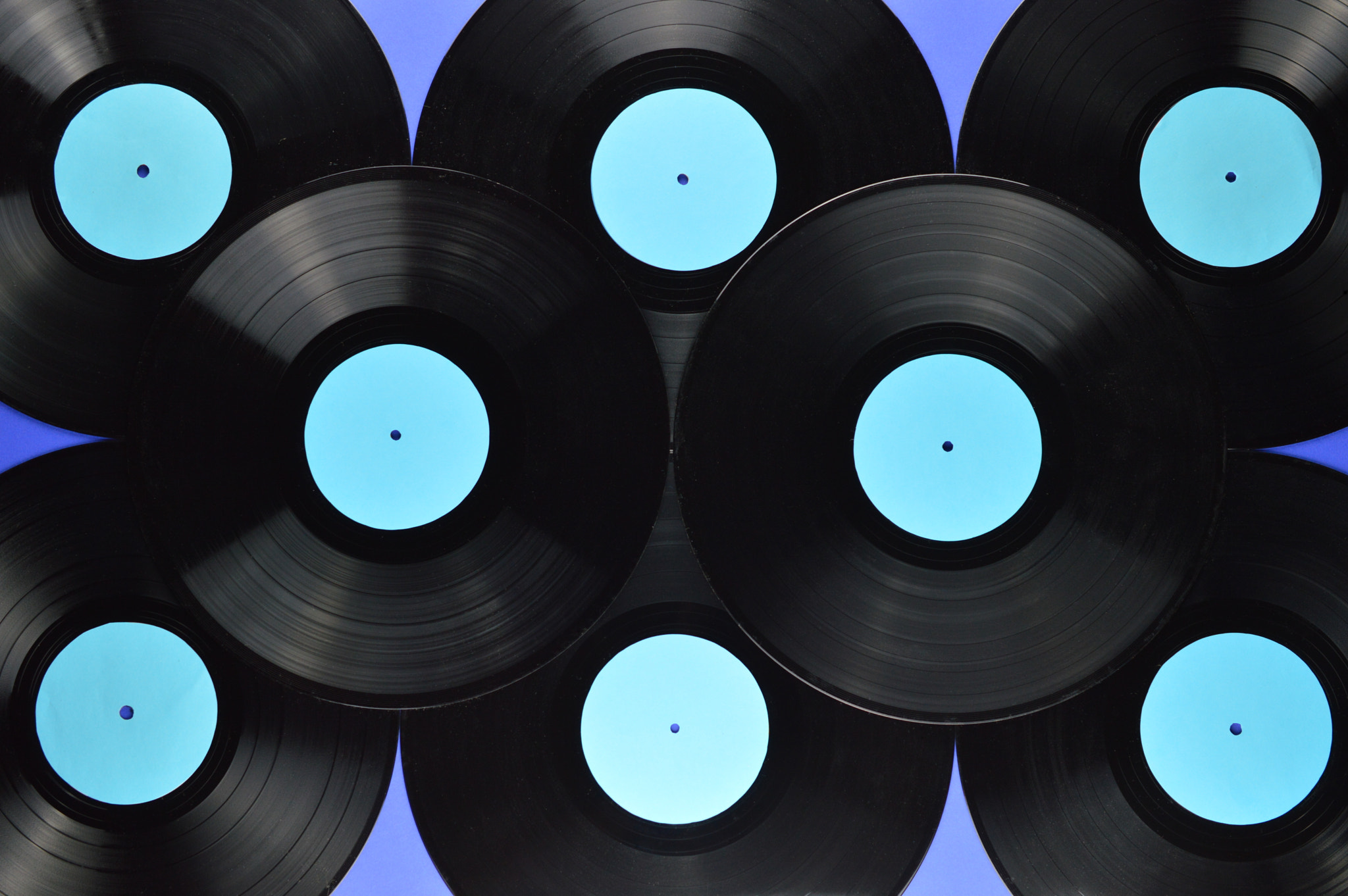 Nikon D3200 sample photo. Pile of black vinyl records on blue photography