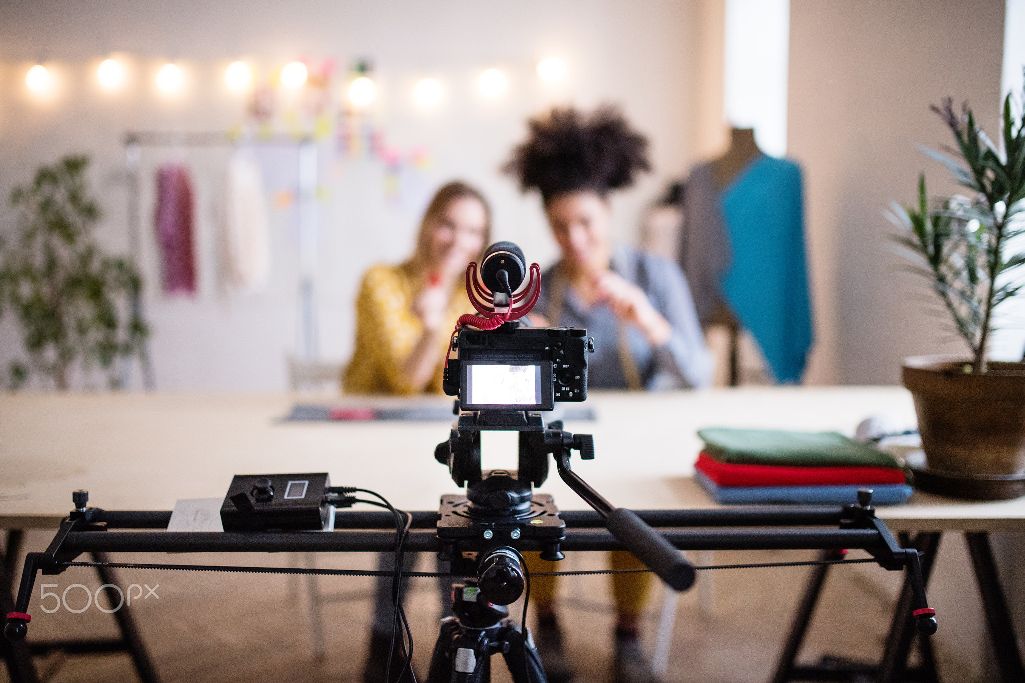 A camera and a slider with women in the background, startup business.