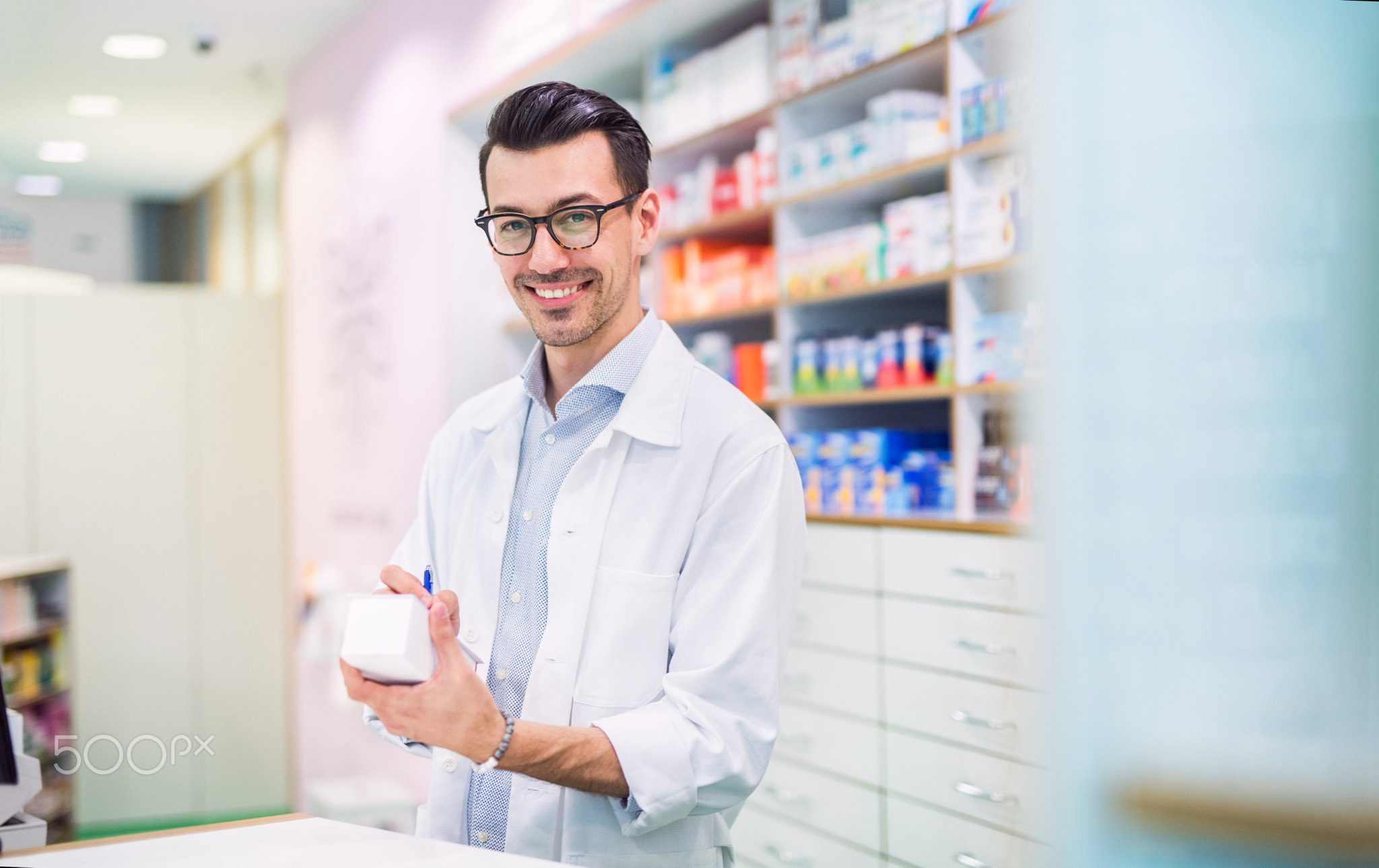 Portrait of a young friendly male pharmacist.