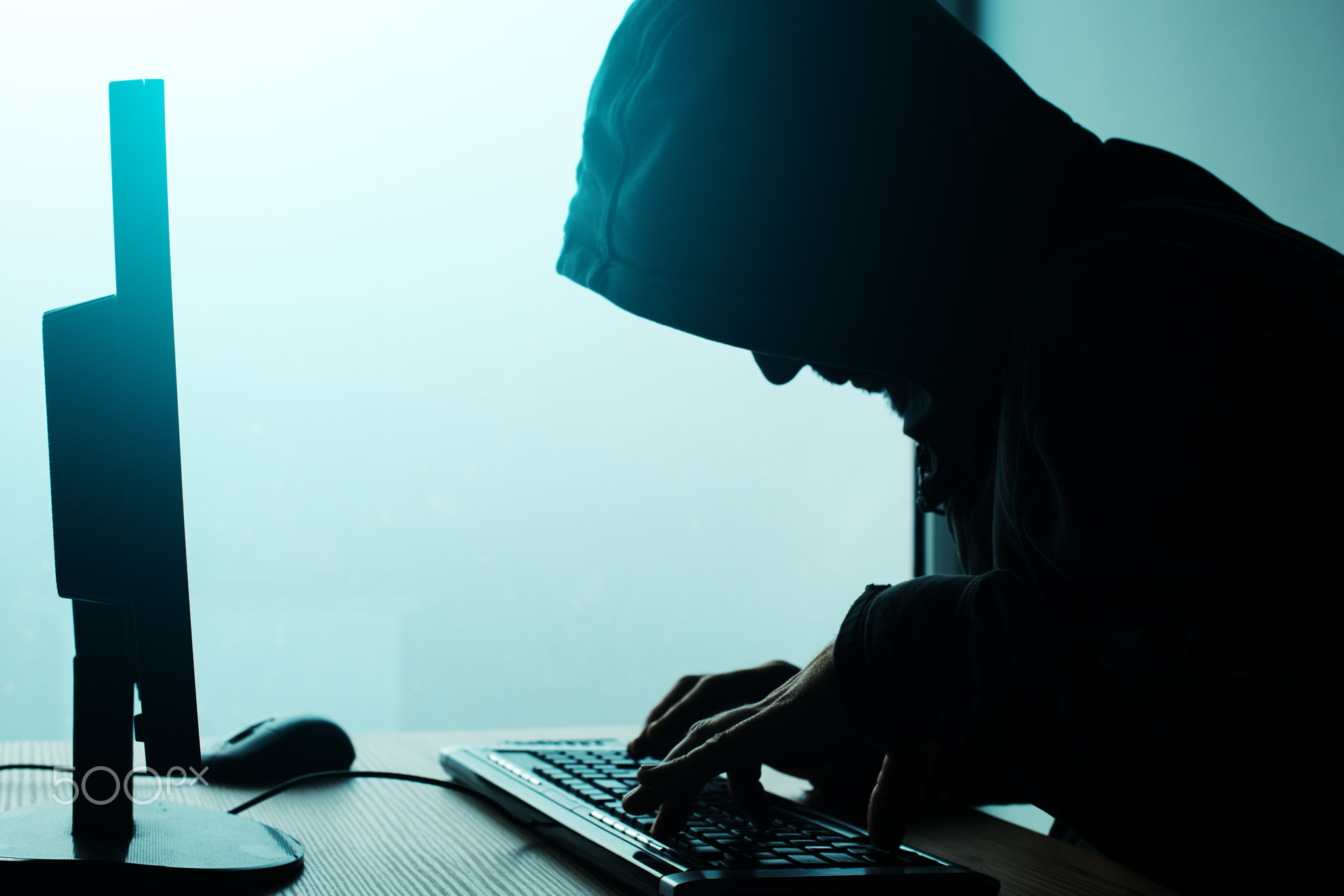 Hooded computer hacker hacking network