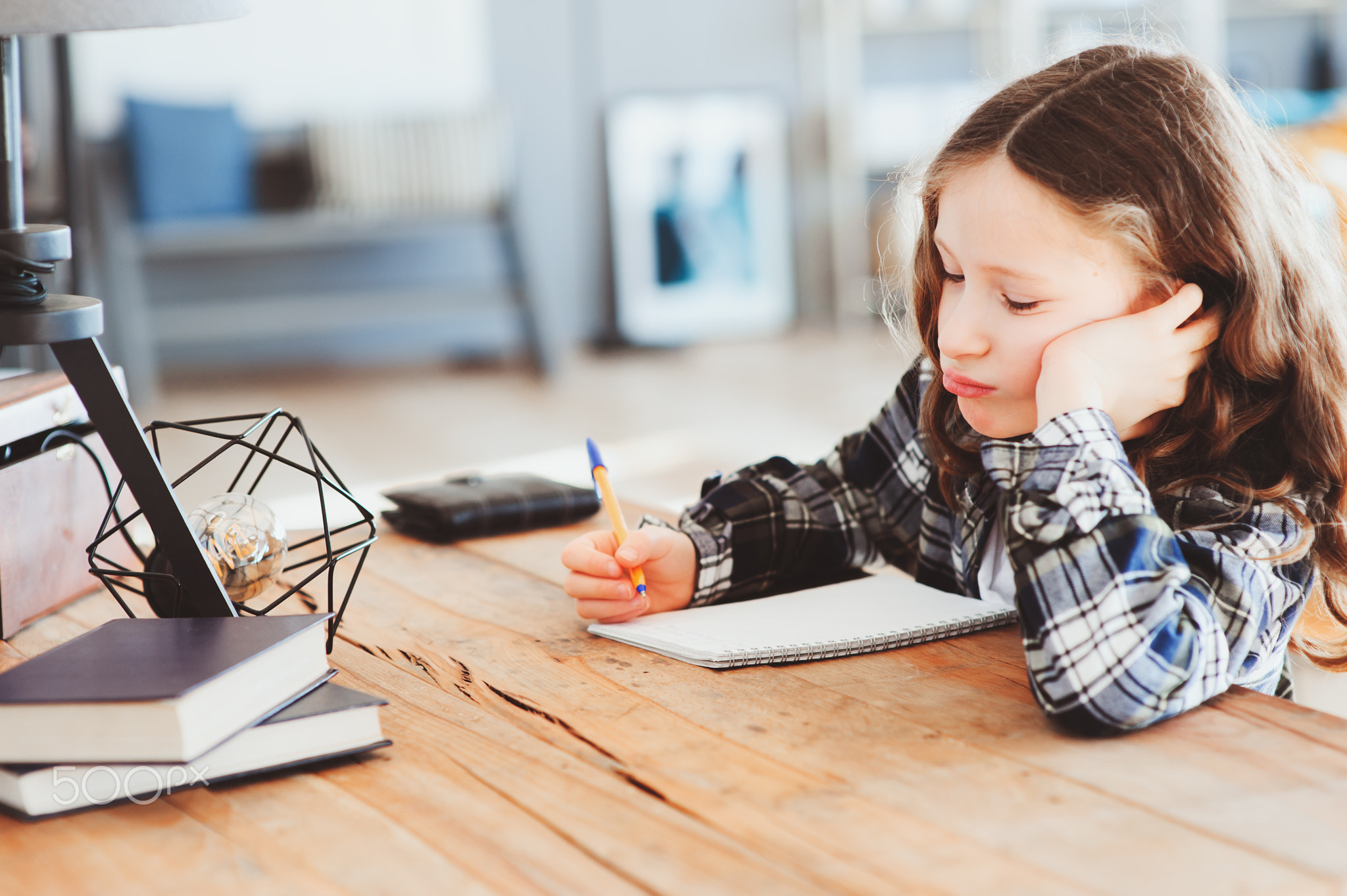 concentrated child girl doing homework. Thoughtful school kid thinking and looking for an answer....