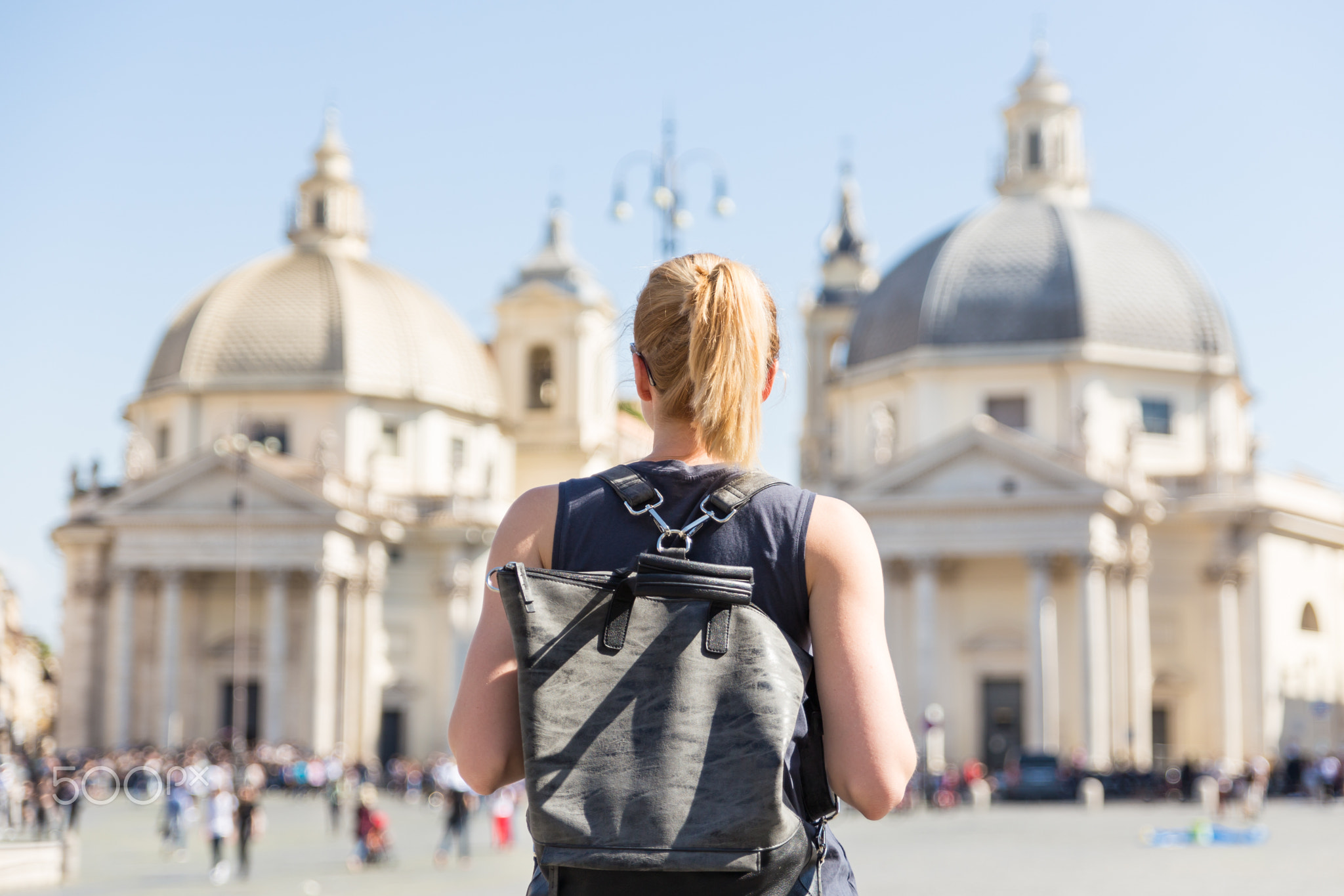 Female tourist with a fashinable vintage hipster backpack on Piazza del Popolo in Rome, Italy.