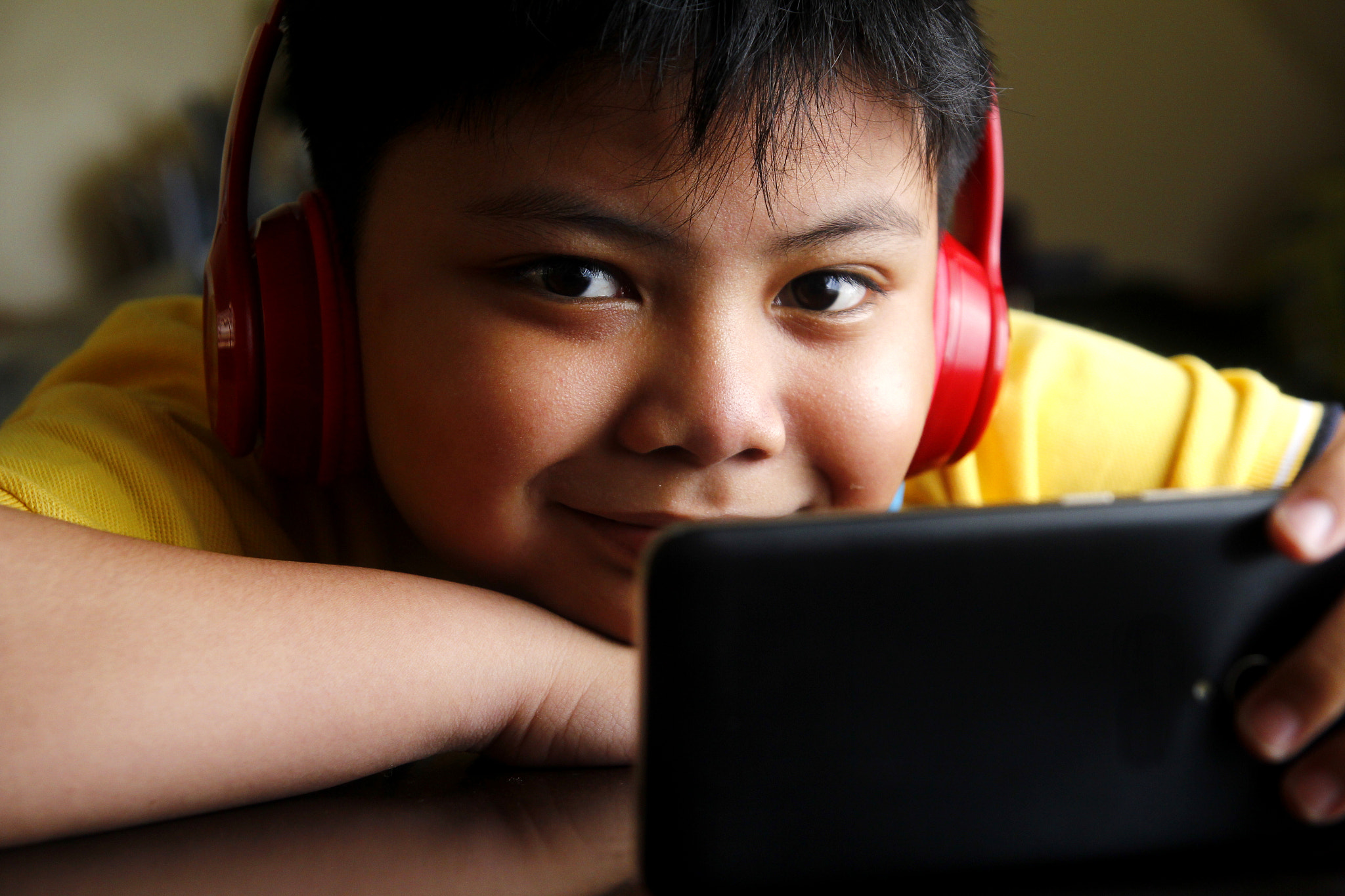 Canon EOS 60D + Tamron SP AF 17-50mm F2.8 XR Di II LD Aspherical (IF) sample photo. Young asian boy with a smartphone and headphones photography