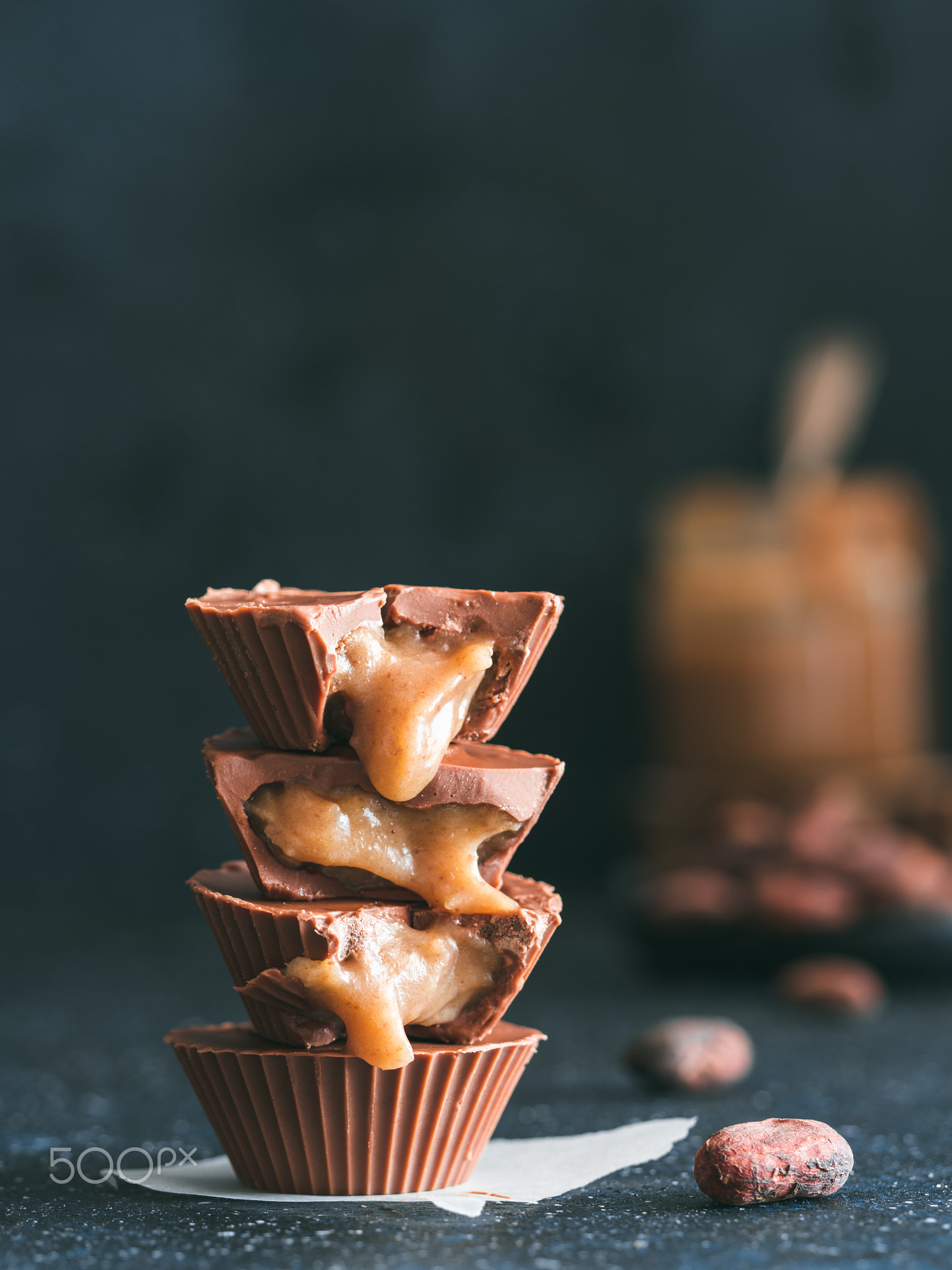 Stack of vegan chocolate cups with caramel on white