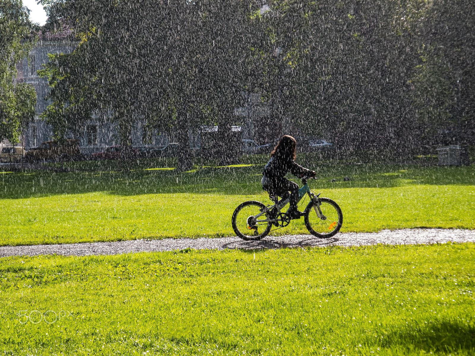 Nikon Coolpix P7100 sample photo. Girl bikes in urban park with rain and sunshine photography