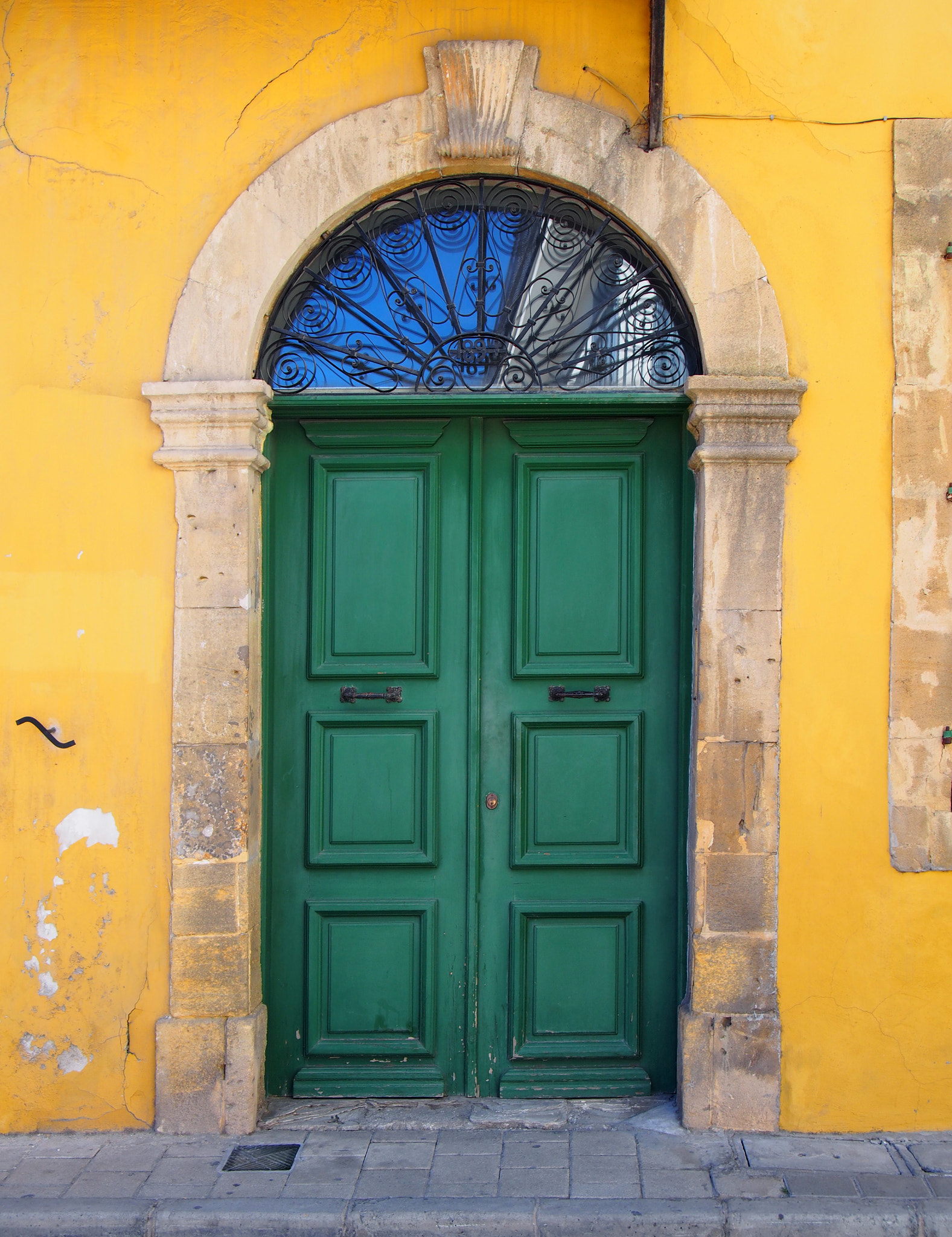 Olympus PEN E-PL6 sample photo. Old double green door in a stone frame in a yellow painted wall typical of the style of old... photography