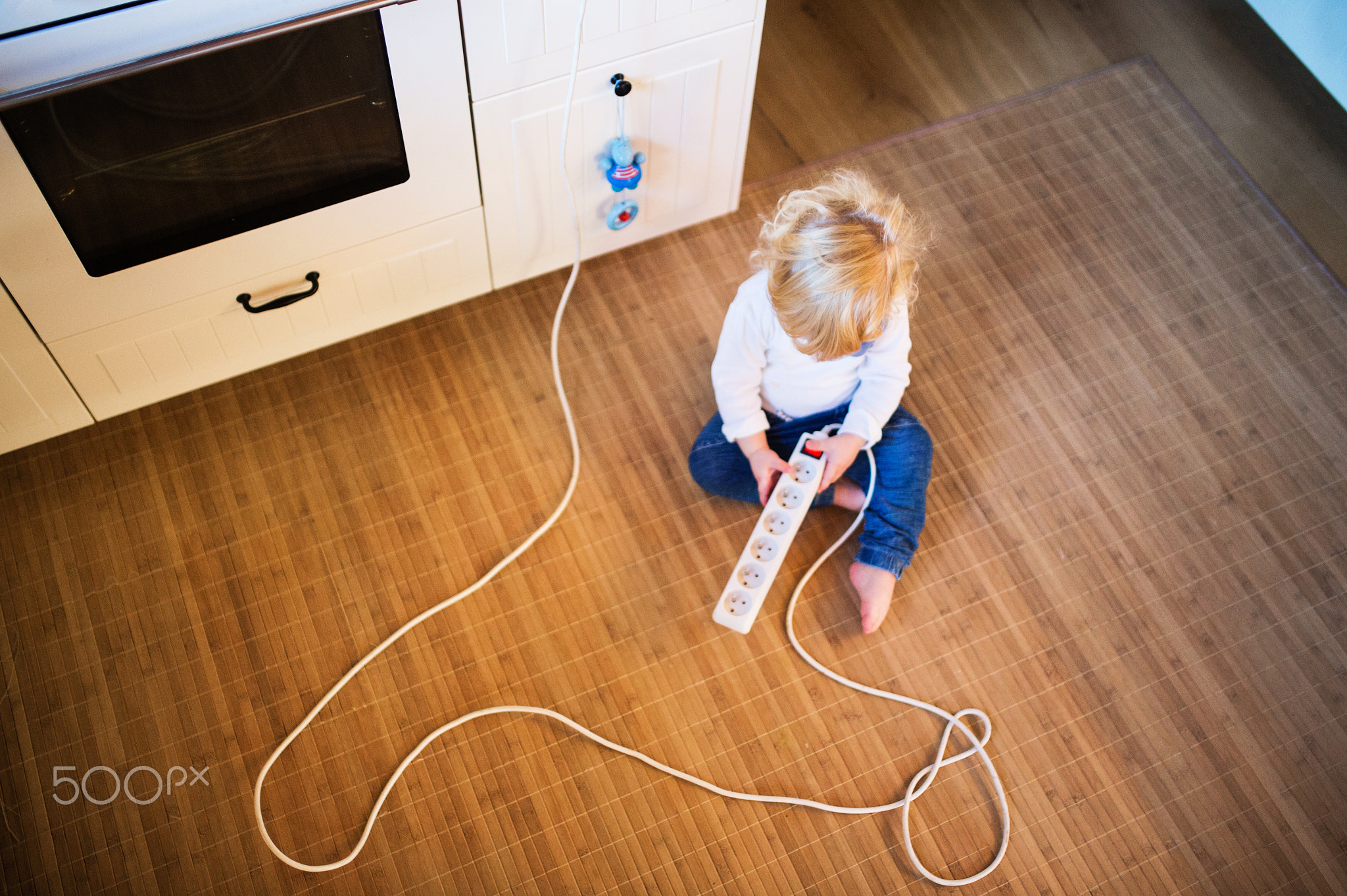 Toddler boy in dangerous situation at home. Child safety concept.