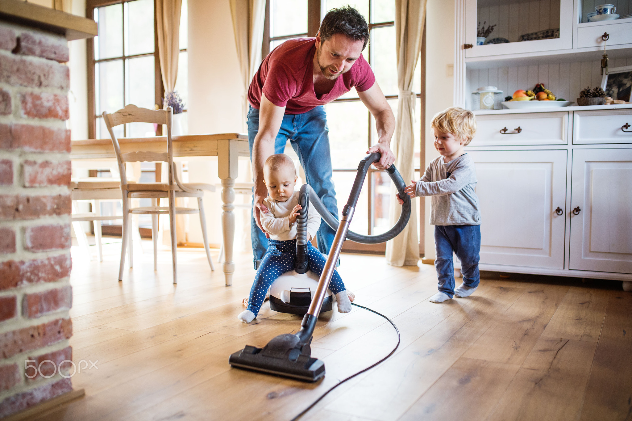 Father and two toddlers doing housework.