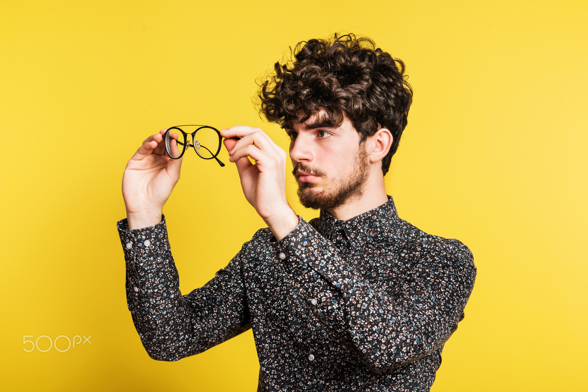 Studio portrait of a young man on a yellow background.